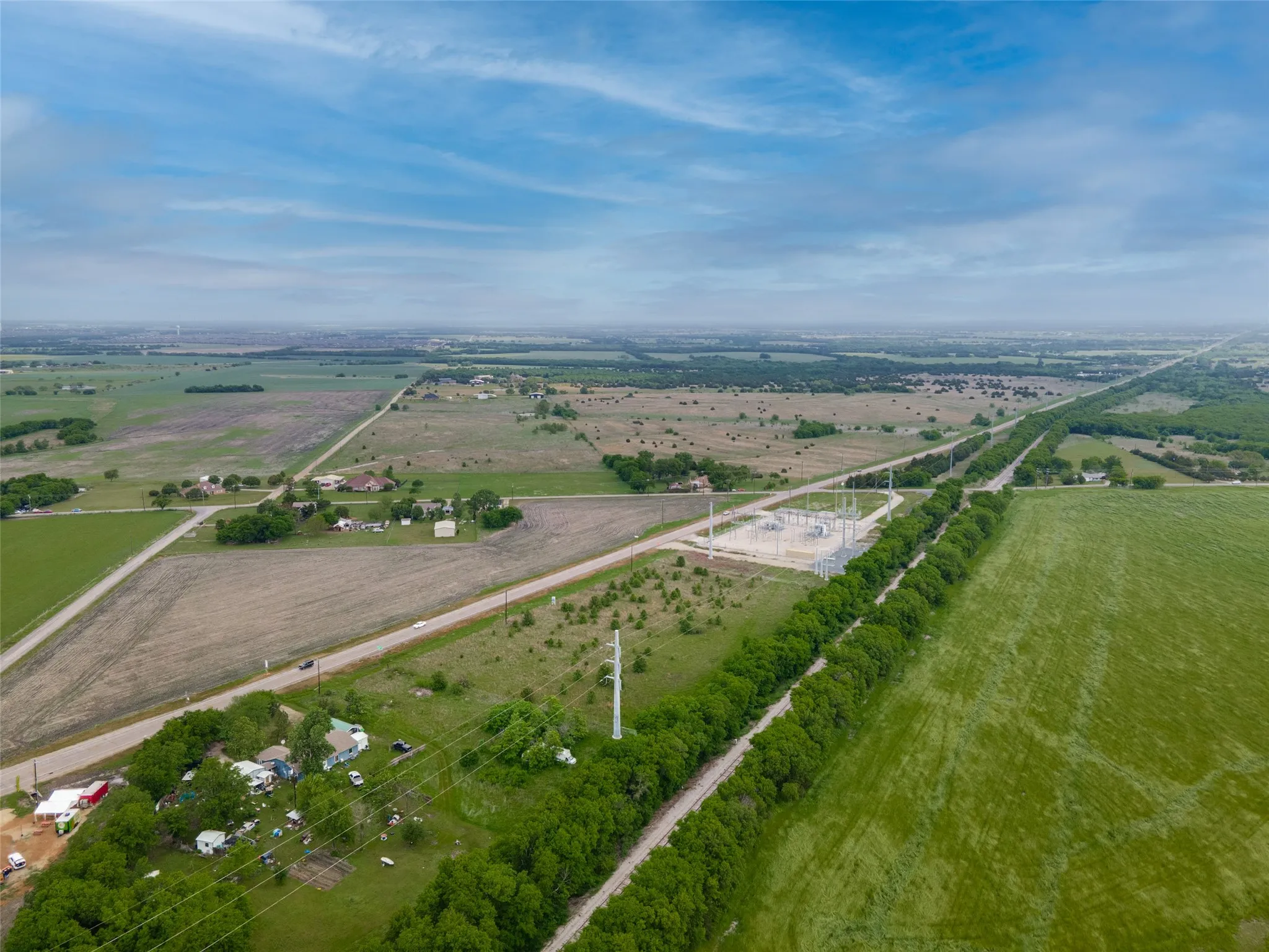 Expansive rural landscape featuring a mix of cultivated fields and undeveloped land