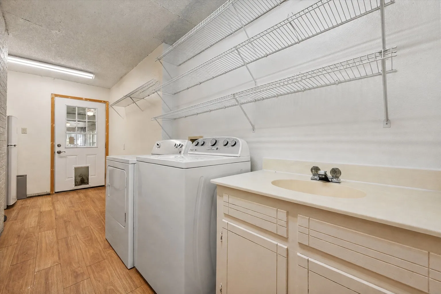 Large utility room with cabinetry, folding counter, and space for full-size appliances.