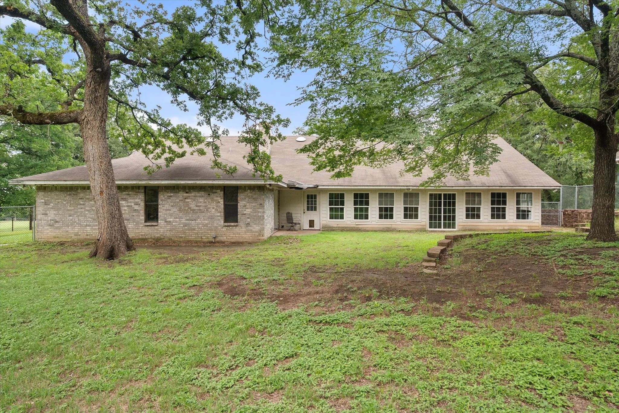 Large backyard with shade trees.