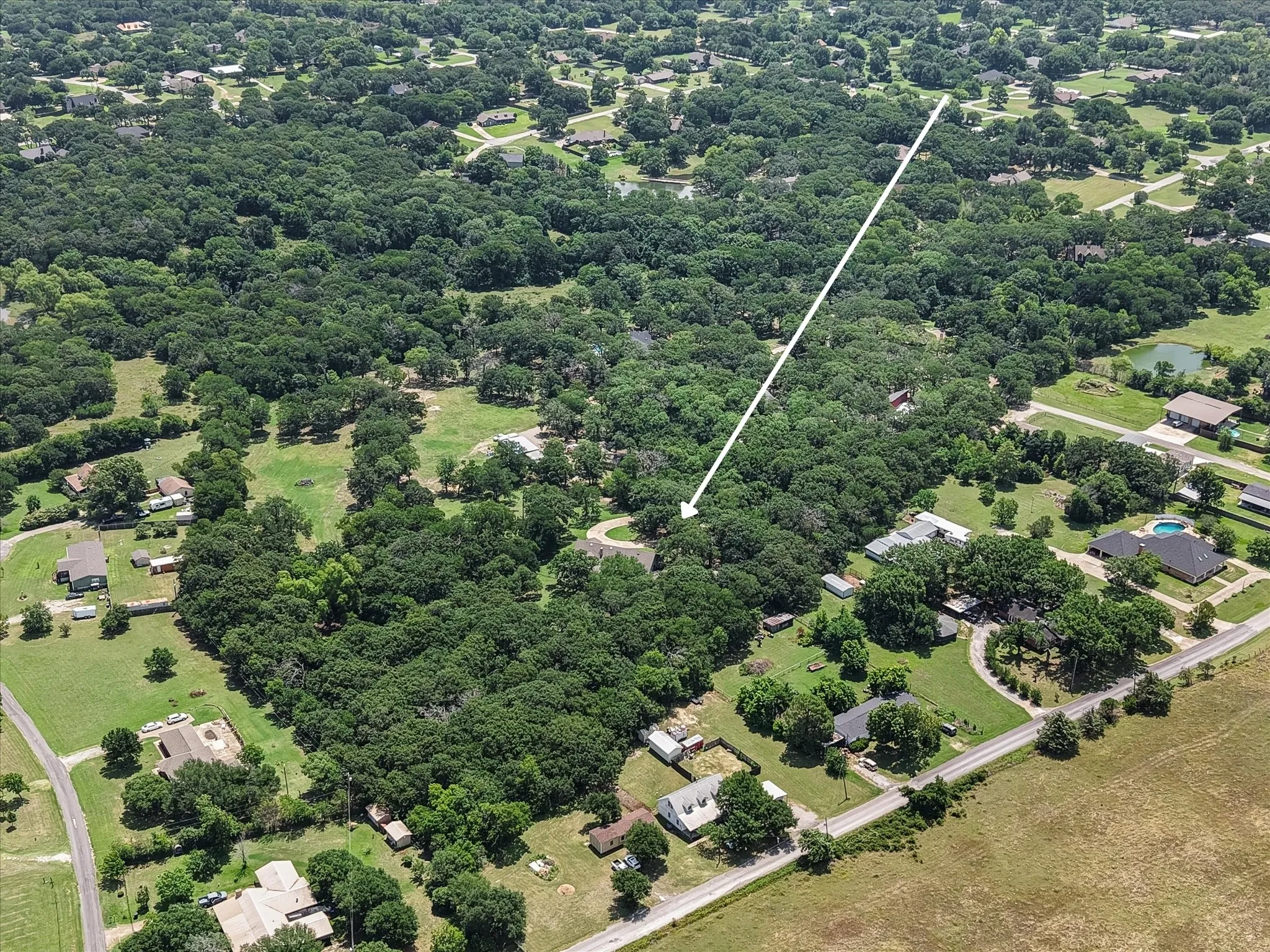Tree-covered acreage surrounds this Corsicana TX home, creating a peaceful setting outside the city limits.