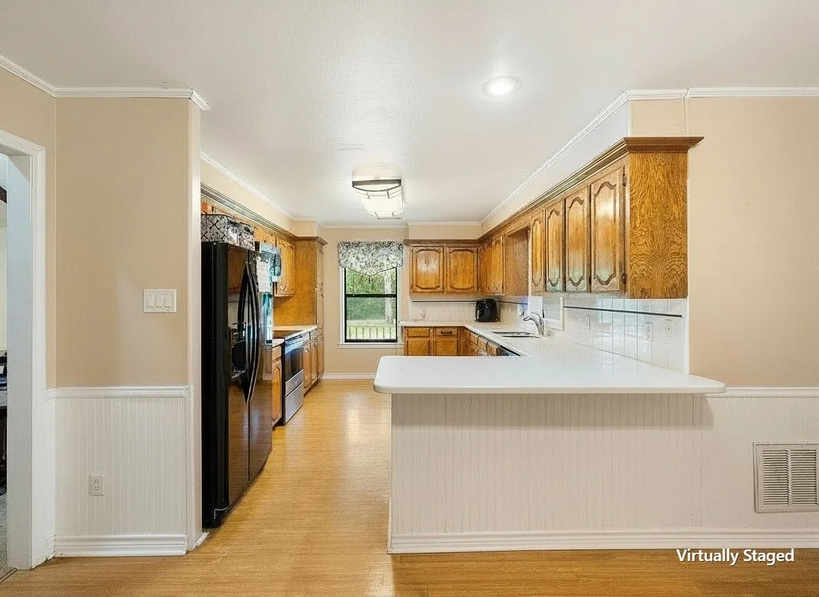 Virtually staged kitchen showcasing the breakfast bar and spacious layout.