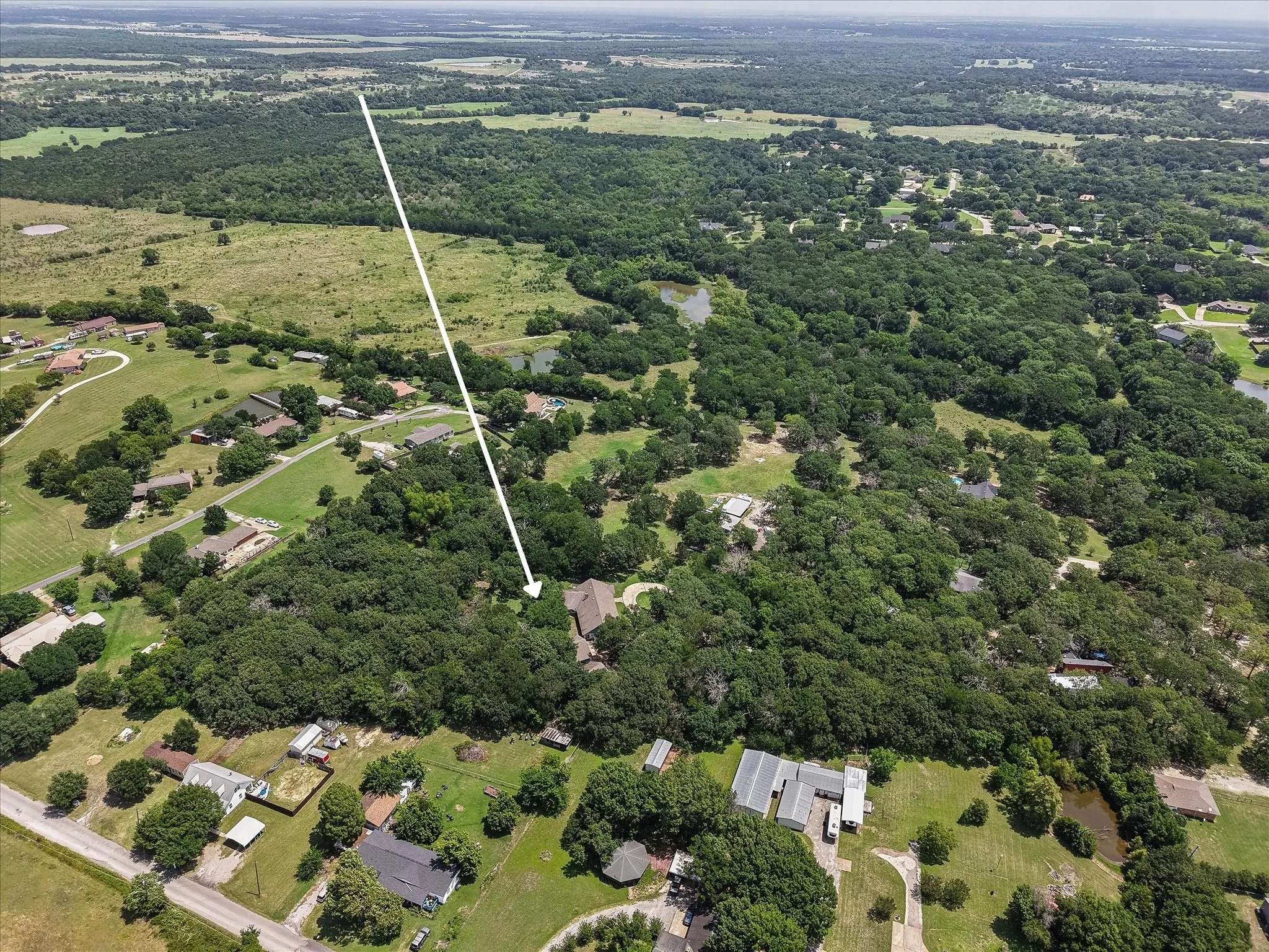 Aerial view of a spacious country property near Richland Chambers Lake with trees, acreage, and rural Texas charm.