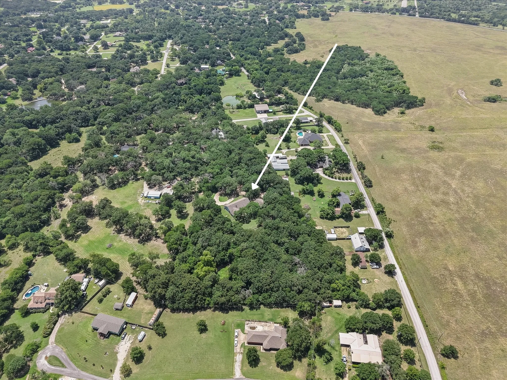 Aerial view of this ranch-style Corsicana home near Ennis, offering privacy, acreage, and a quiet county road location.