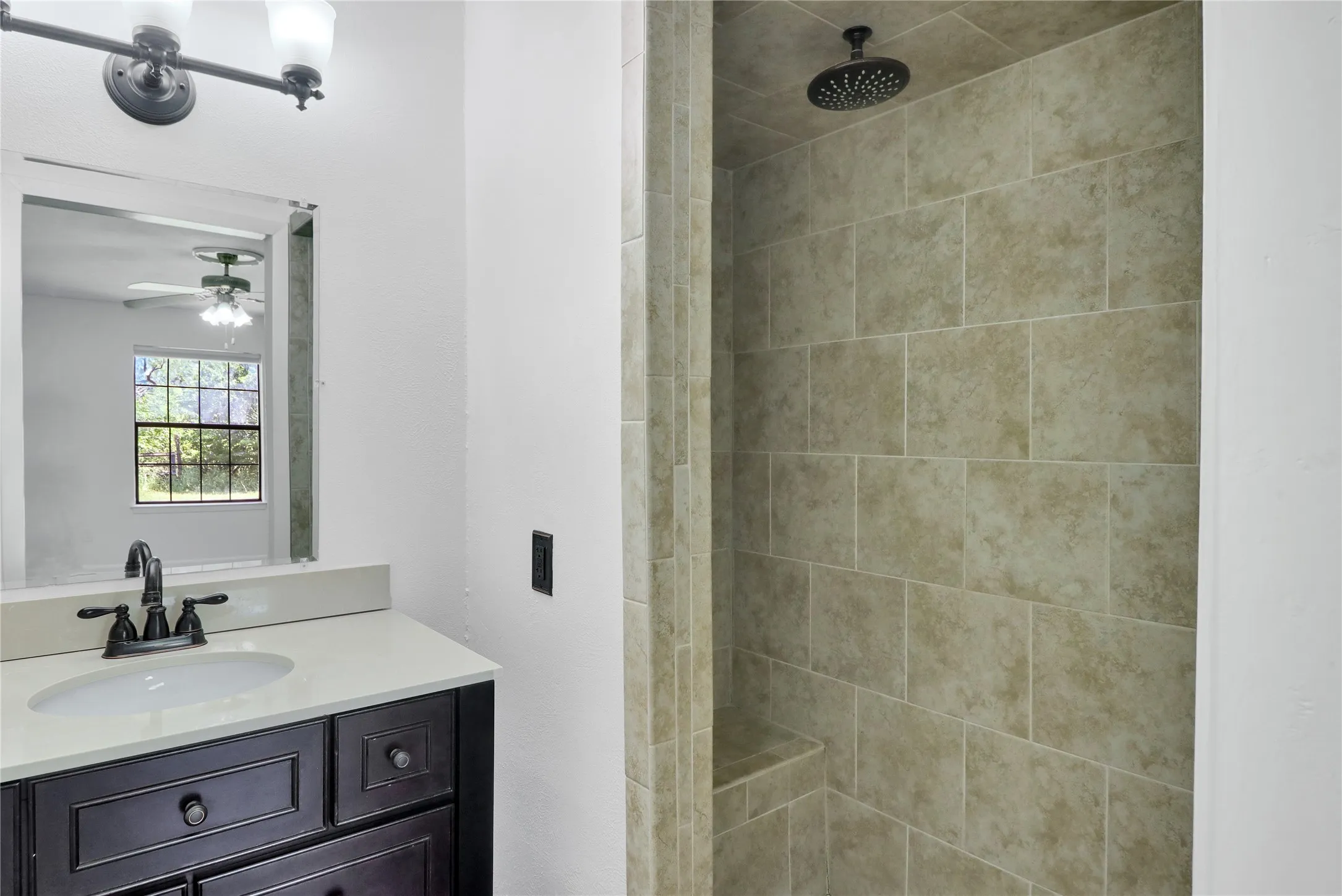 Vanity with dark wood cabinetry, white countertop, and integrated sink