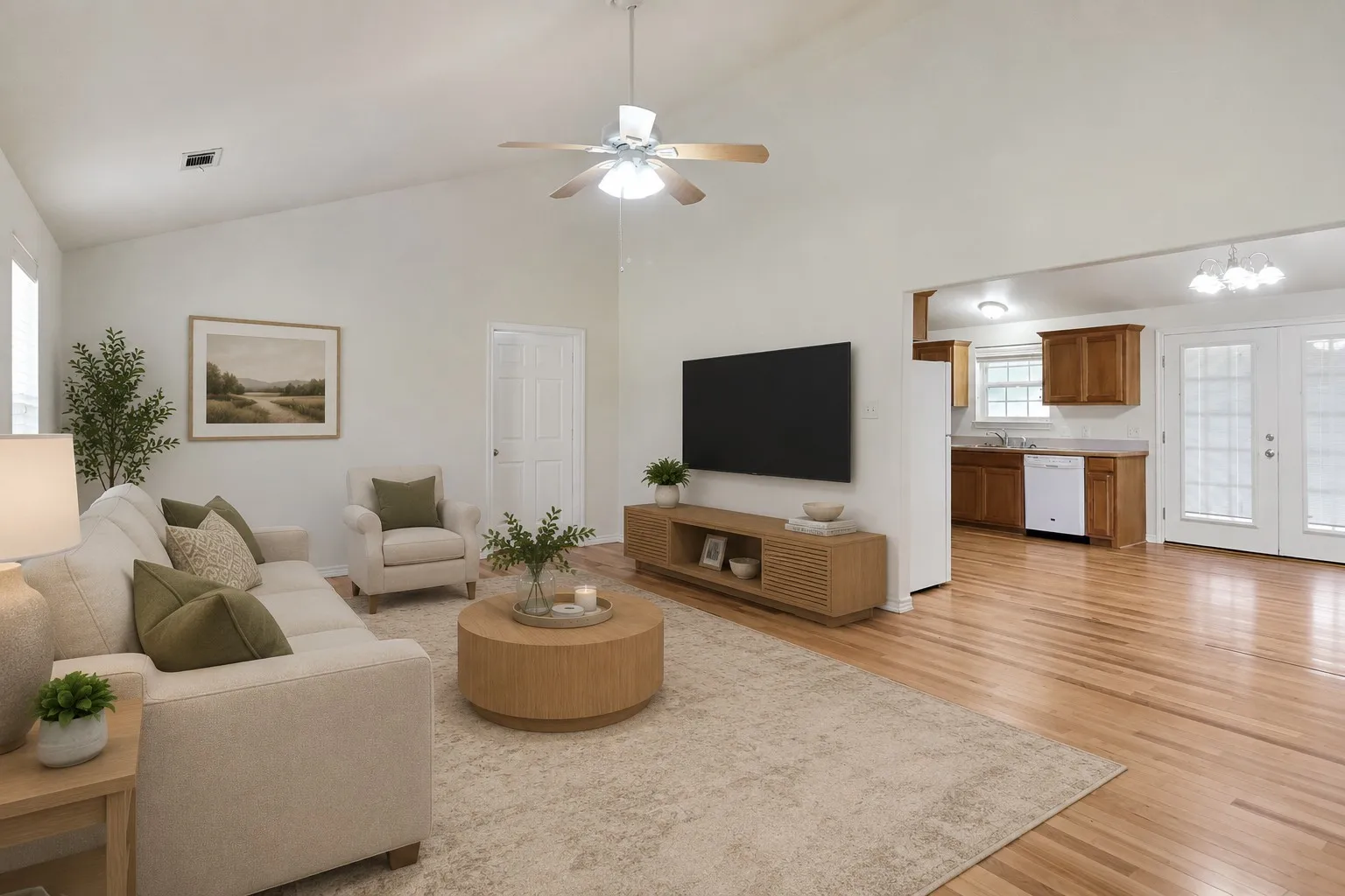 Virtual Staging Vaulted ceilings accentuate this living area featuring wood-finish flooring and a ceiling fan