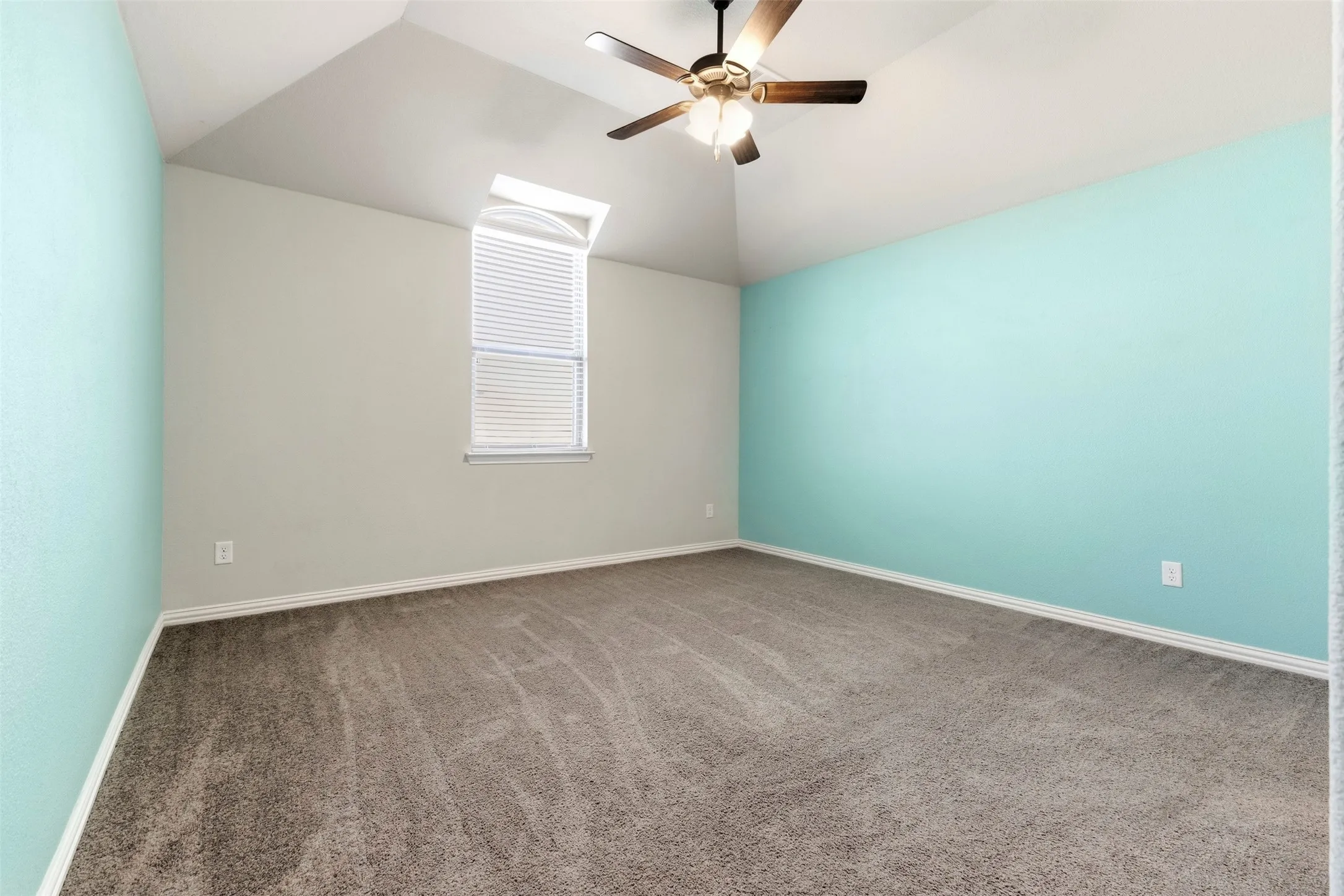 Vaulted ceiling room featuring carpet flooring, a ceiling fan, and a window with blinds