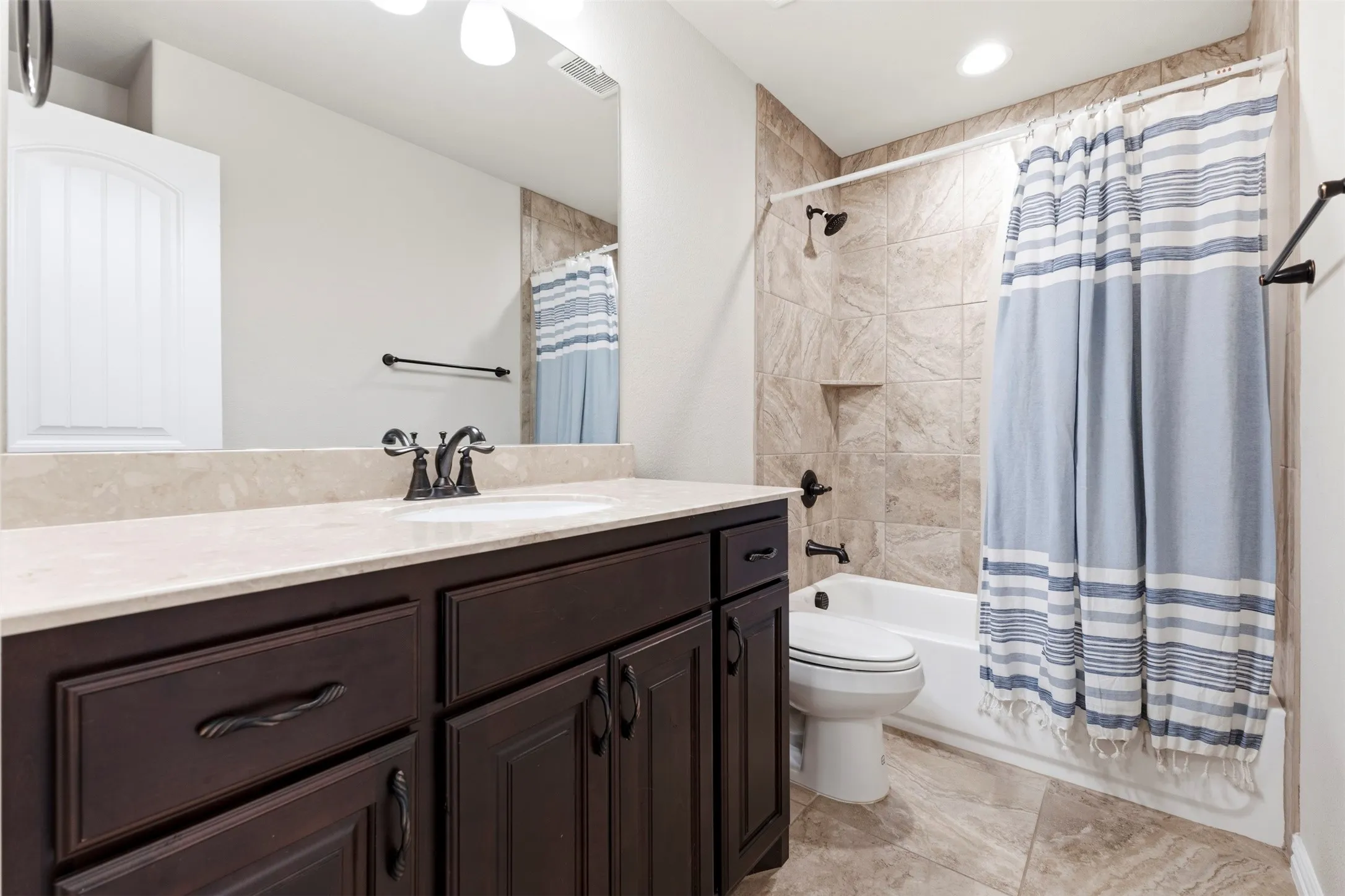 Spa-inspired master bath featuring a dark wood vanity with dual sinks, white quartz countertop, and oil-rubbed bronze fixtures