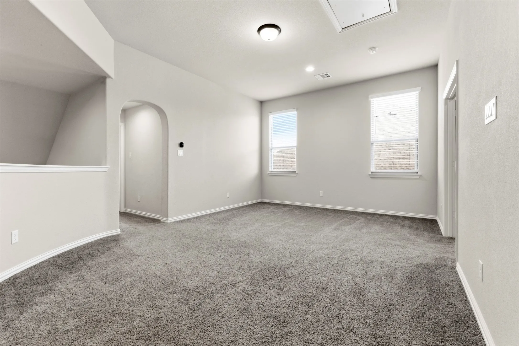 Spacious room featuring neutral wall finishes, recessed ceiling lighting, and plush carpeting throughout