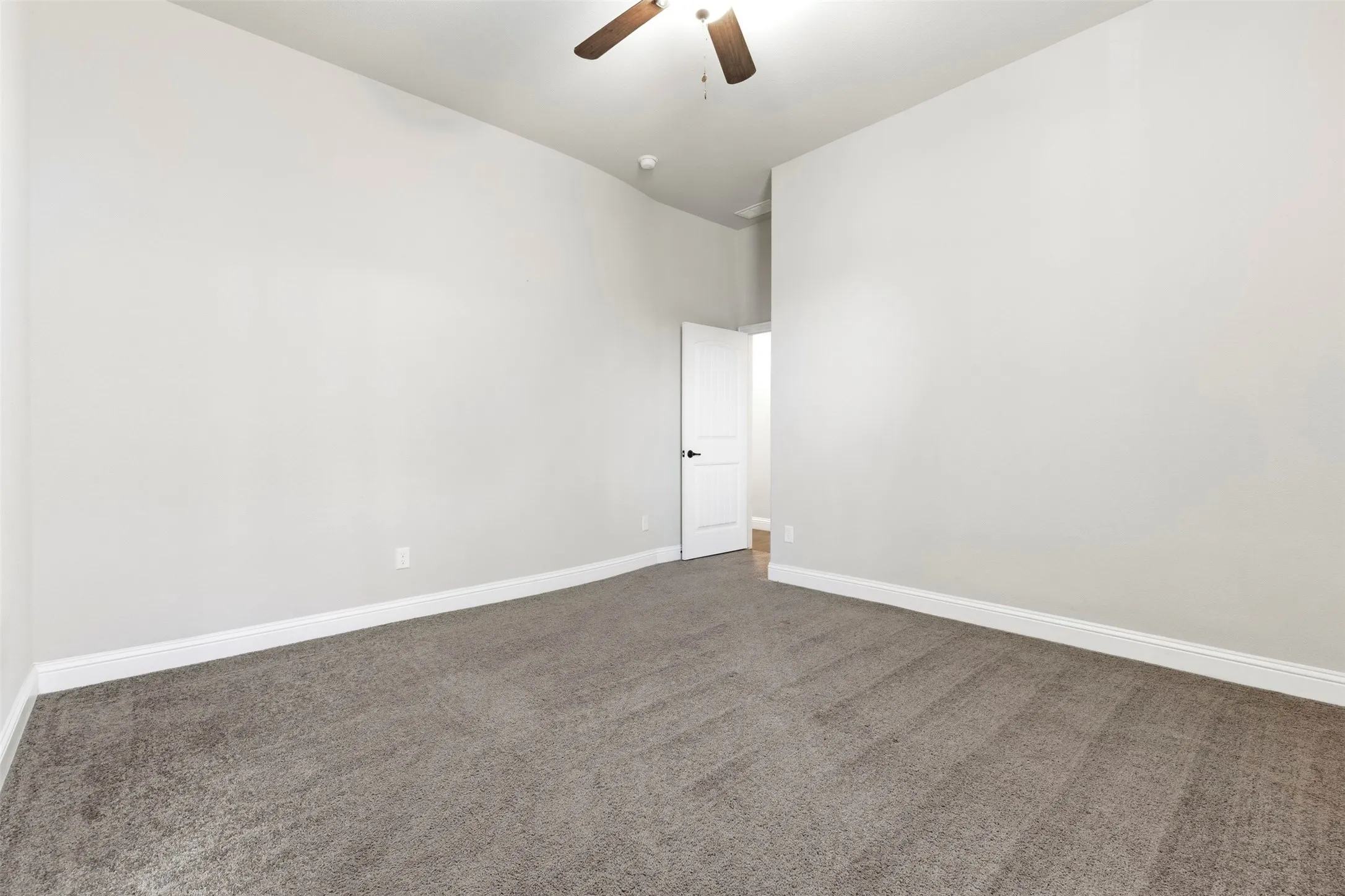 Spacious bedroom with neutral wall finishes, recessed ceiling lighting, and soft gray carpet flooring