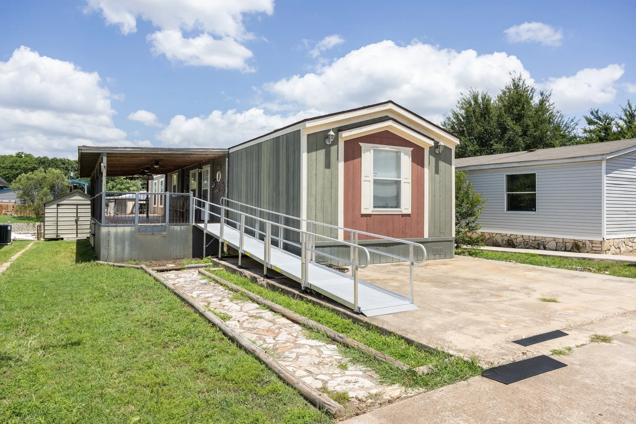 Exterior featuring a covered porch, a wheelchair ramp, and an outdoor storage shed