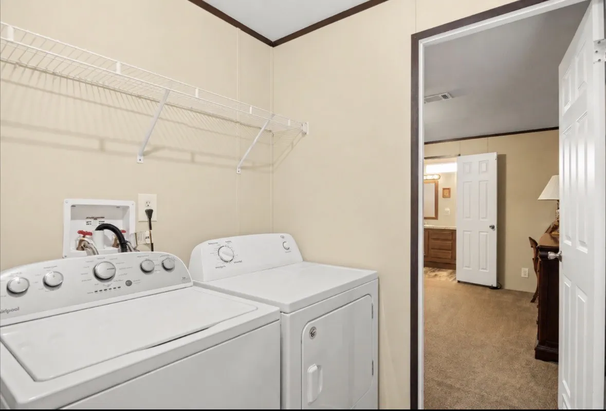 Dedicated laundry area featuring wire shelving, wall-mounted connections, and neutral-toned walls