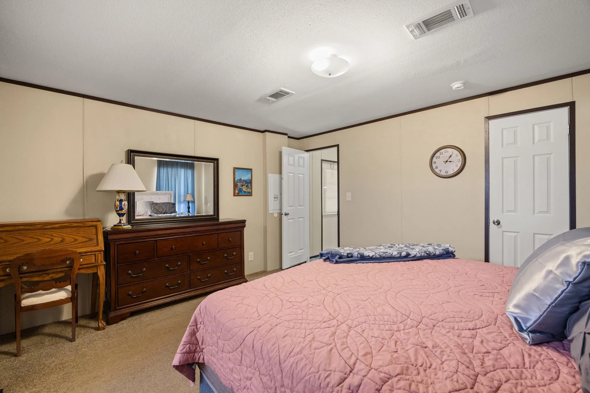 Carpeted room with neutral wall panels and dark trim