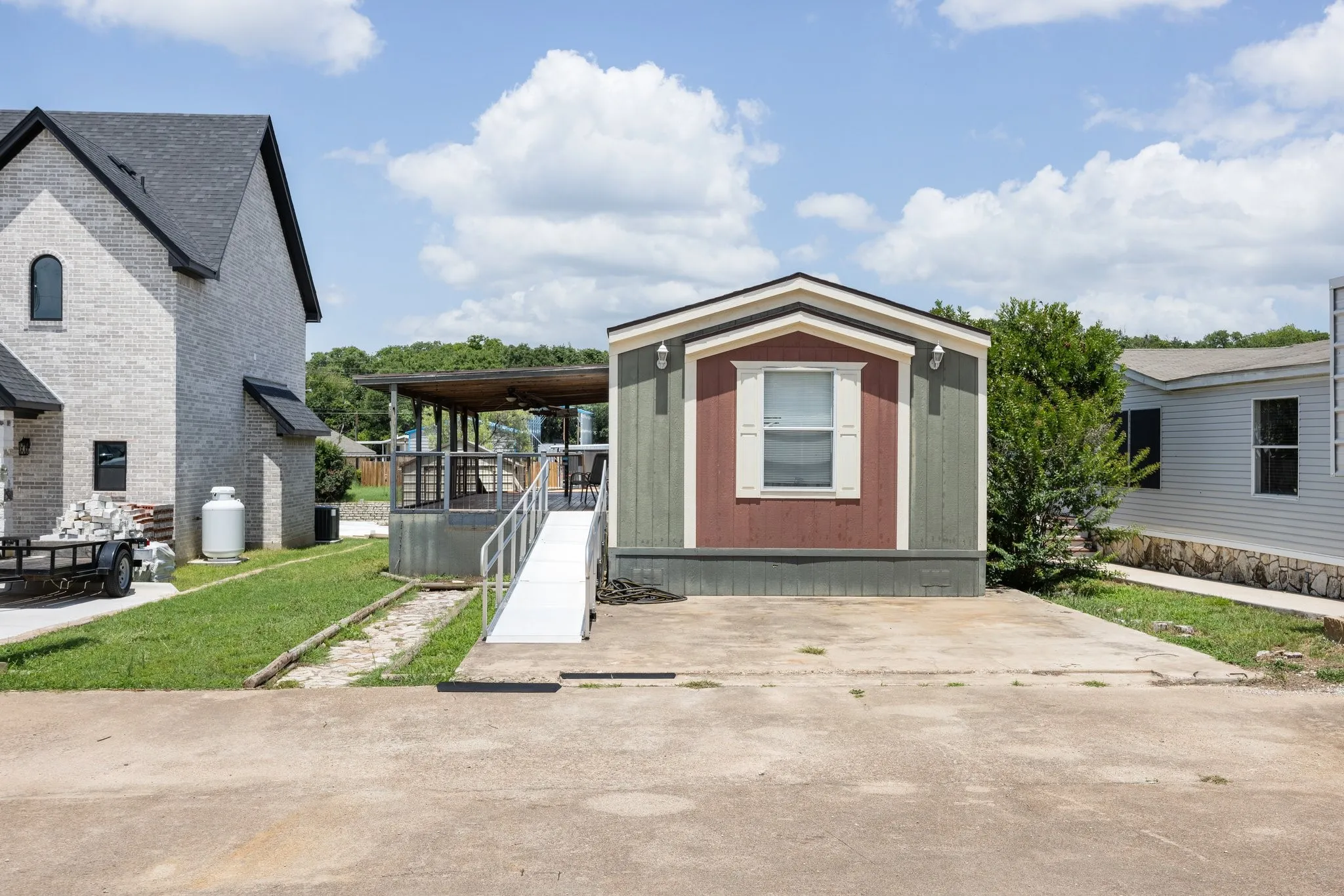Property exterior featuring a multi-toned facade, decorative window shutters, and a concrete pad