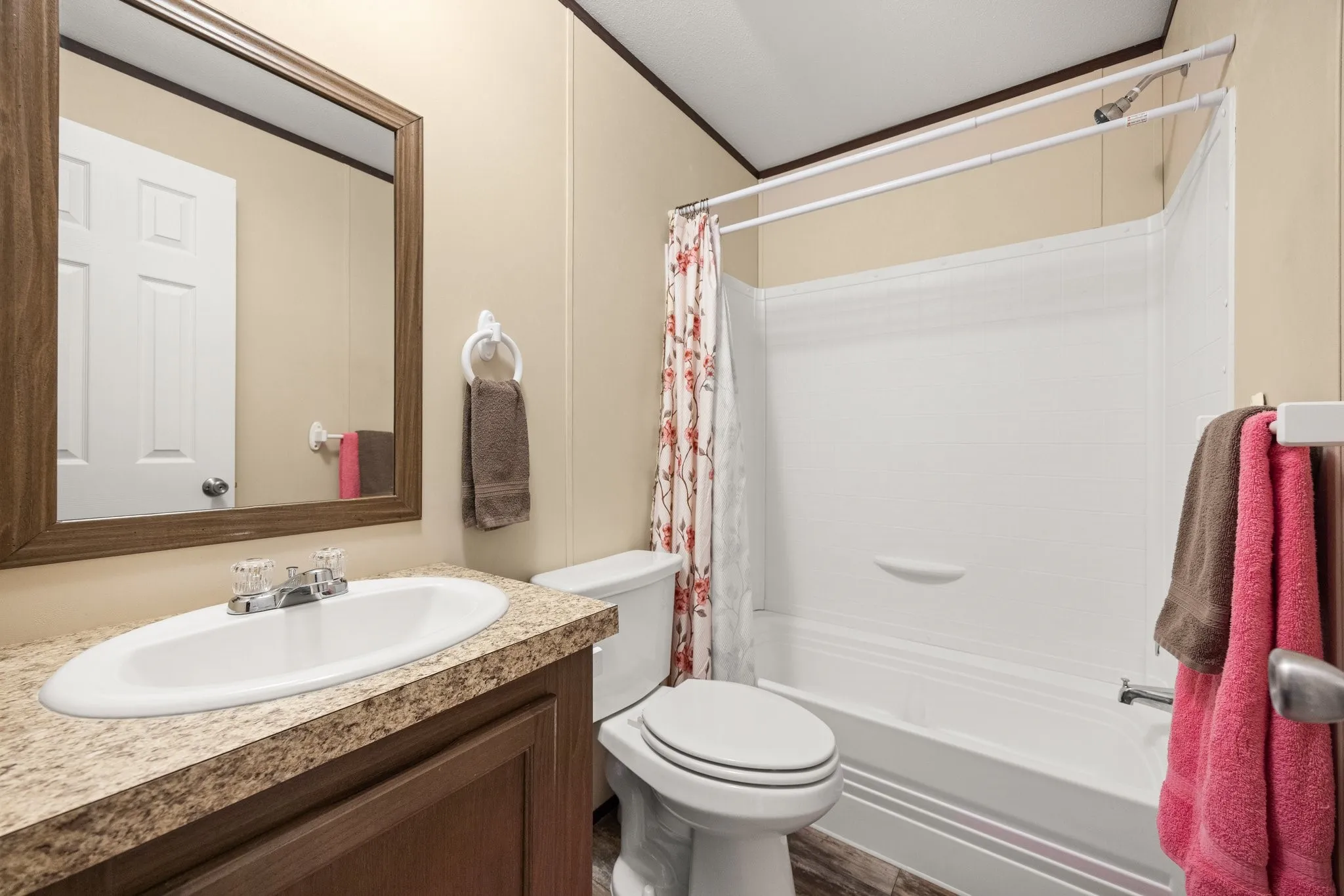Full bathroom featuring a white tub/shower combination, white toilet, and a vanity with a laminate countertop and oval undermount sink
