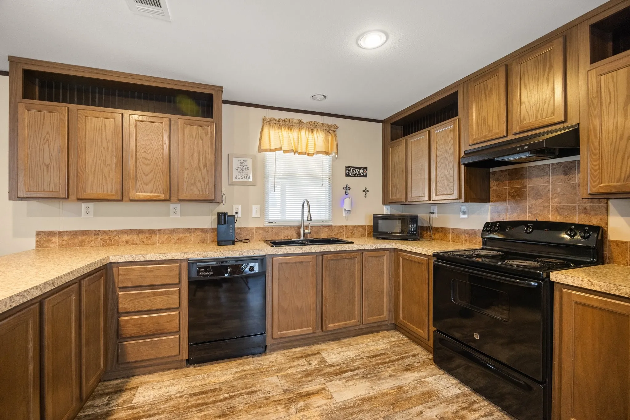 Kitchen featuring wood-finish cabinetry, solid surface countertops, and a tile backsplash