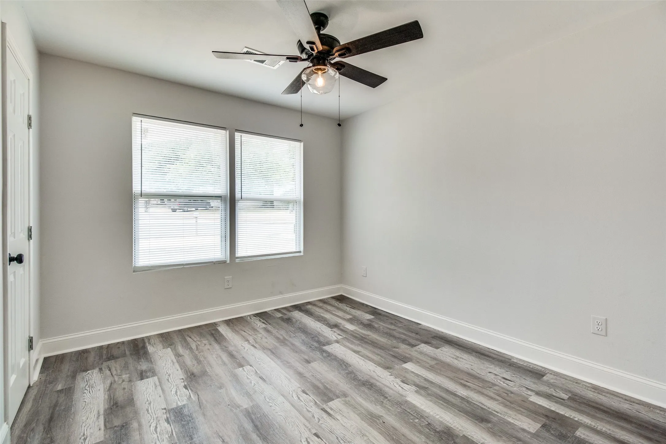 Empty room with ceiling fan and light hardwood / wood-style floors