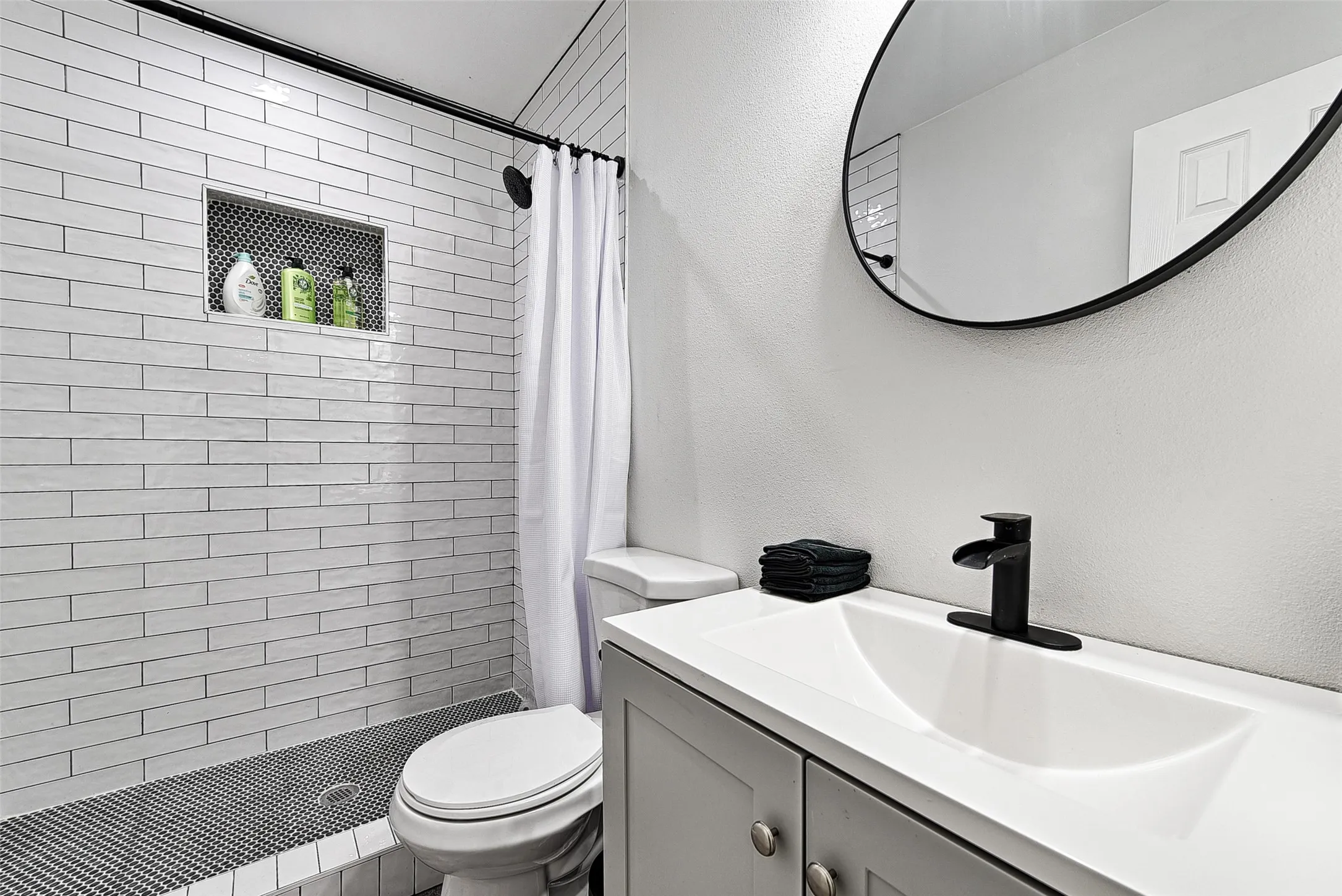 Bathroom featuring toilet, a shower with curtain, and vanity