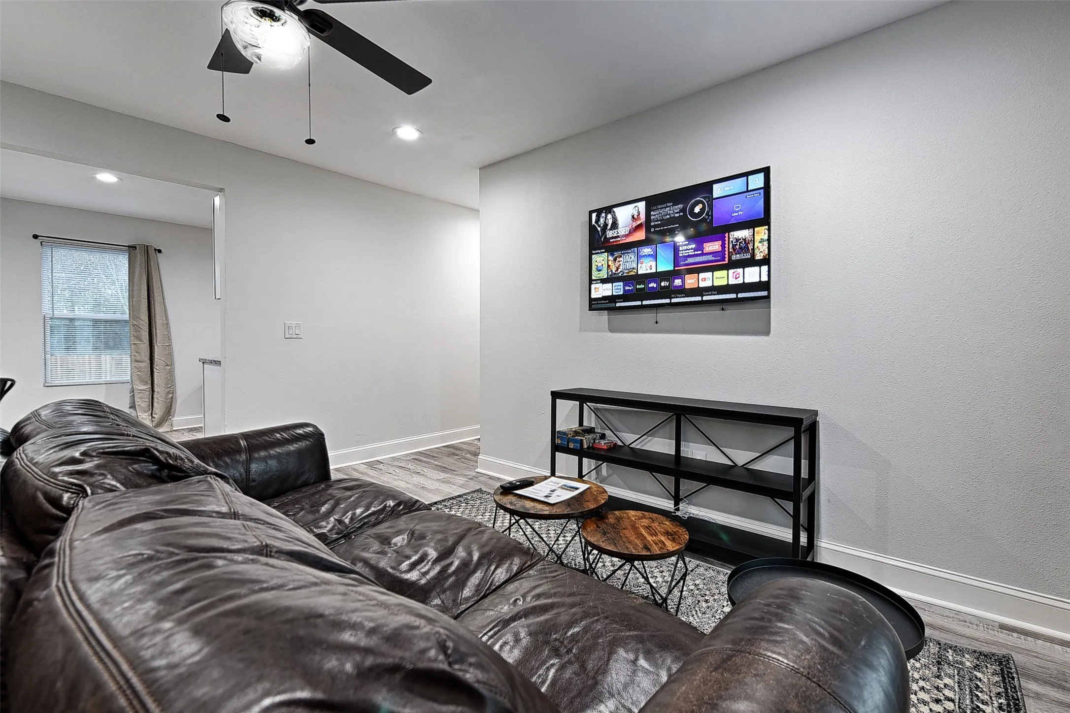Living room featuring wood-type flooring and ceiling fan