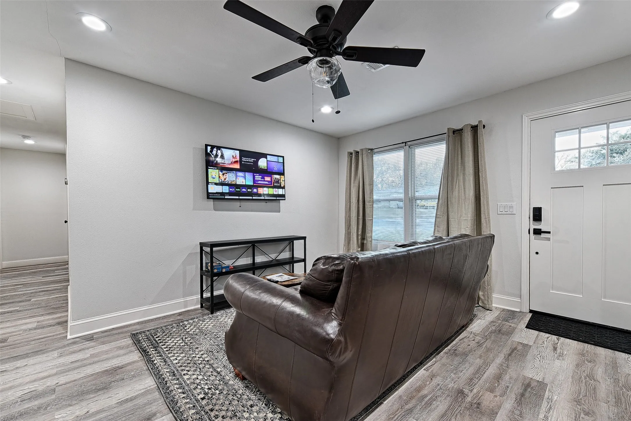 Living room featuring a wealth of natural light, ceiling fan, and light hardwood / wood-style flooring