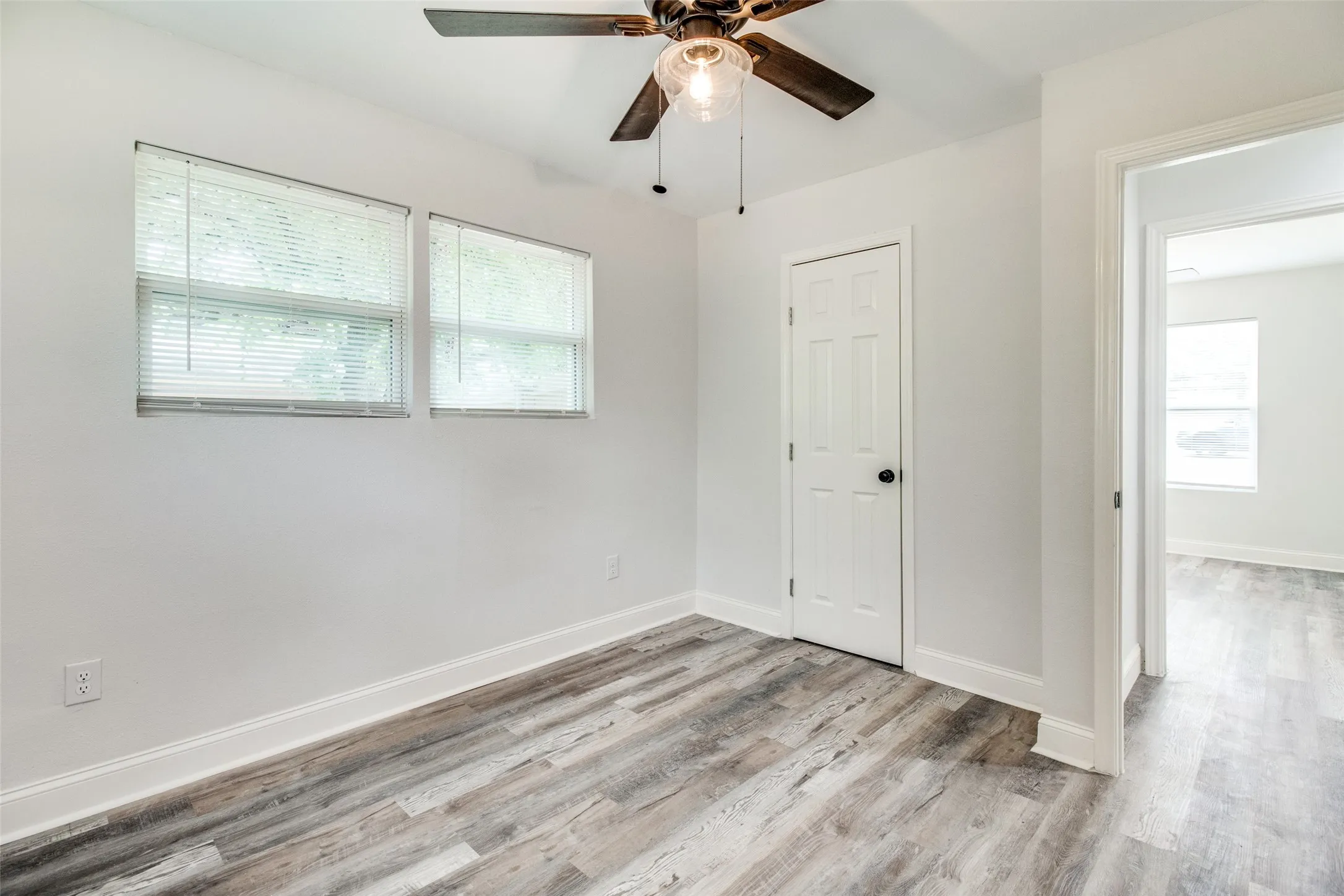 Spare room with plenty of natural light, light hardwood / wood-style floors, and ceiling fan