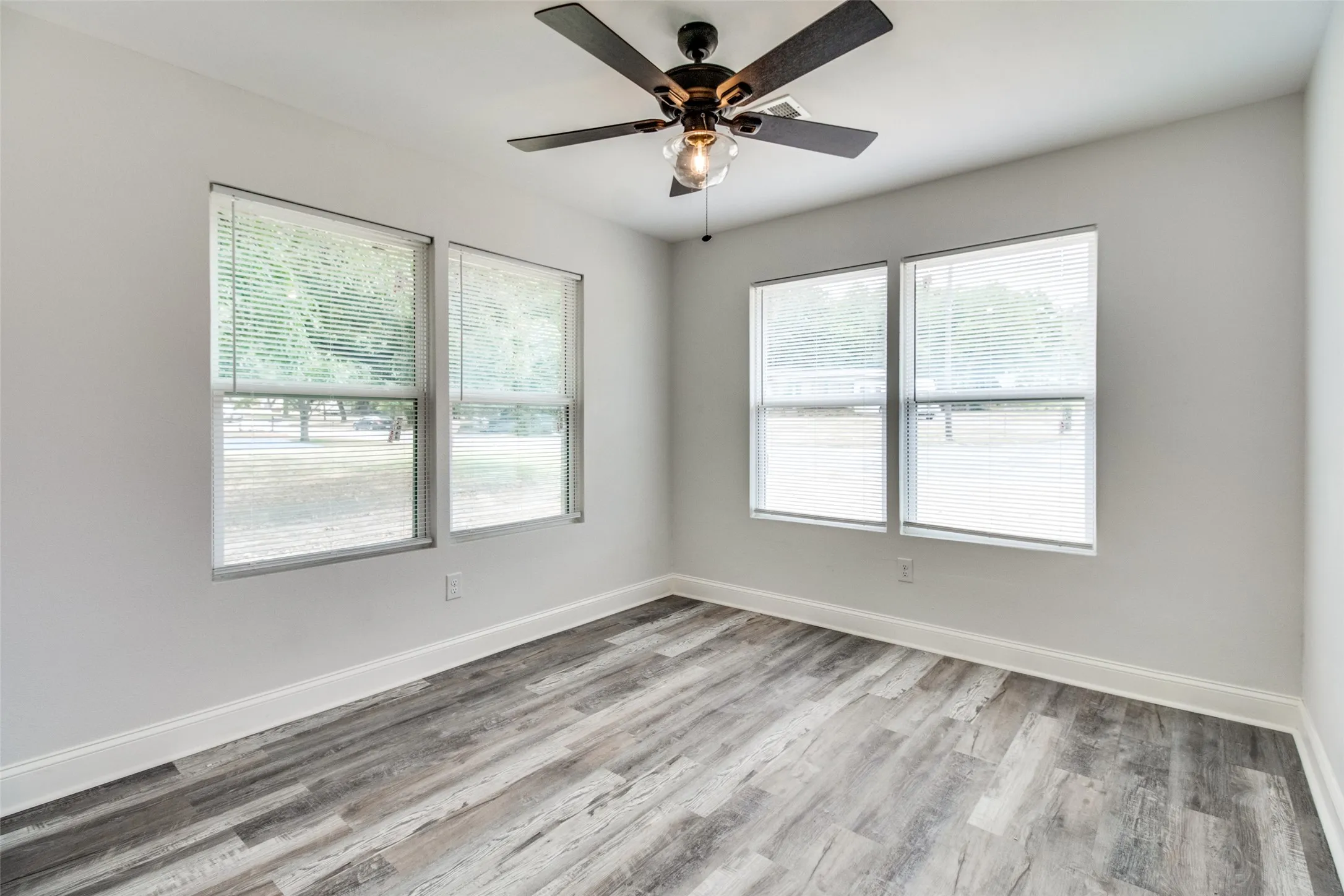 Unfurnished room with ceiling fan and light hardwood / wood-style flooring