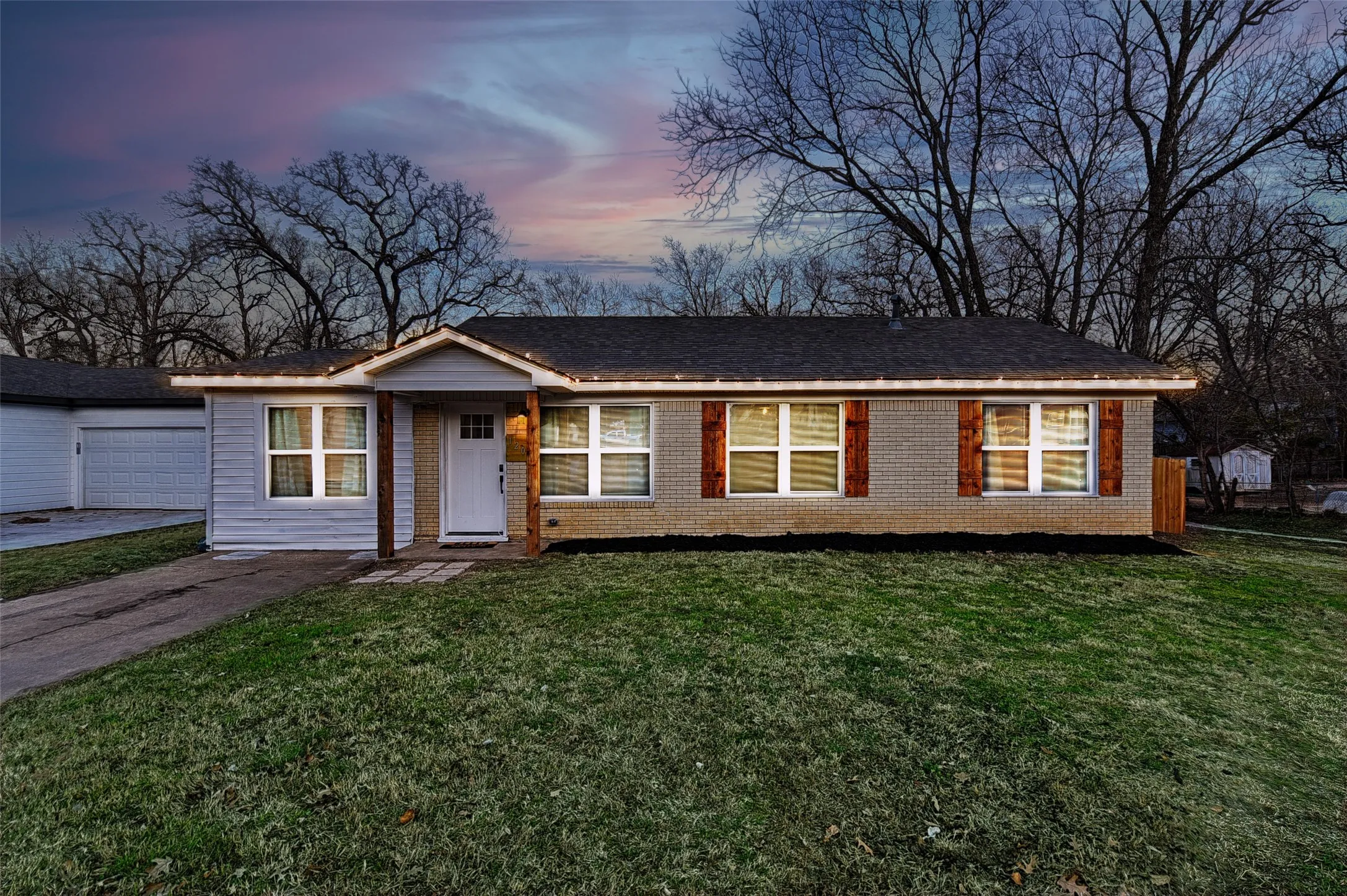 Single story home with a garage and a lawn