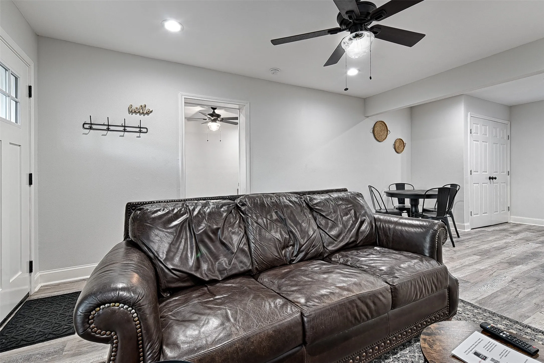 Living room with light hardwood / wood-style floors and ceiling fan