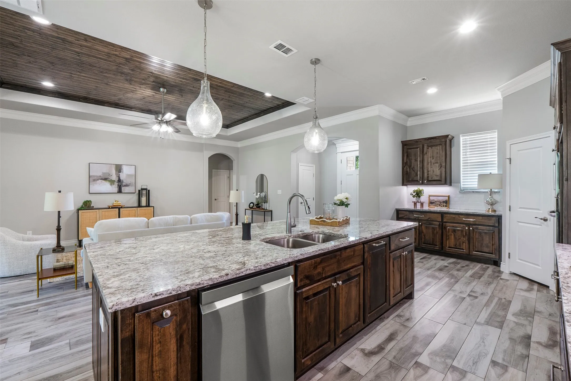 Spacious kitchen island with seating, granite countertops, custom cabinetry and abundant storage.
