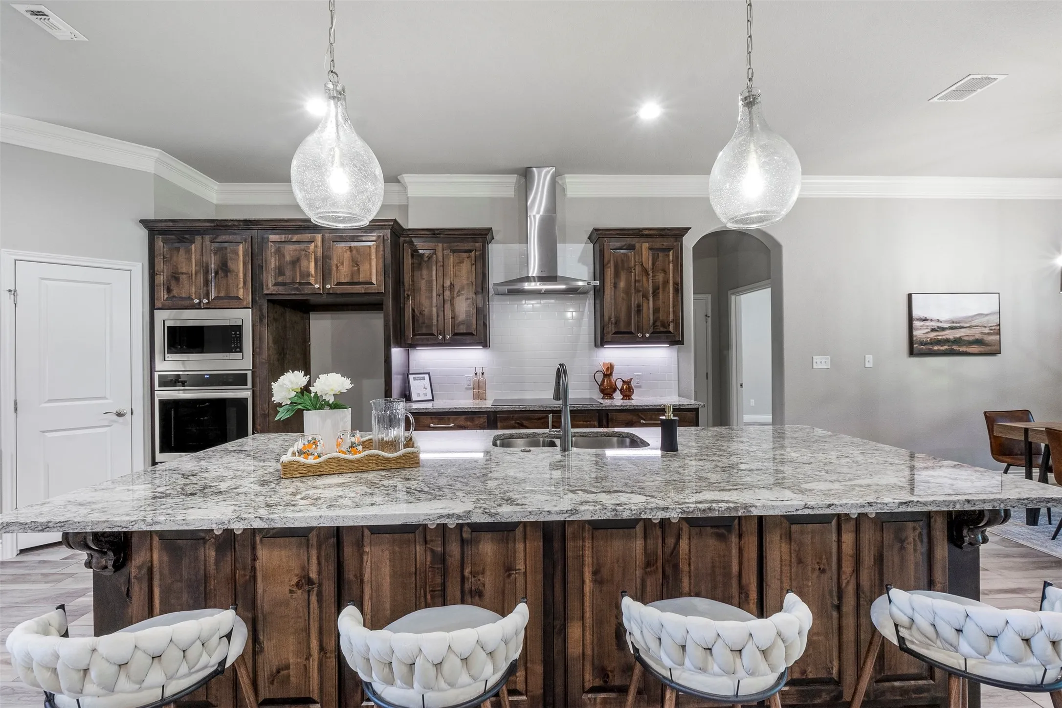 Large kitchen with granite countertops, custom stained cabinetry, stainless appliances, generous workspace and oversized island.