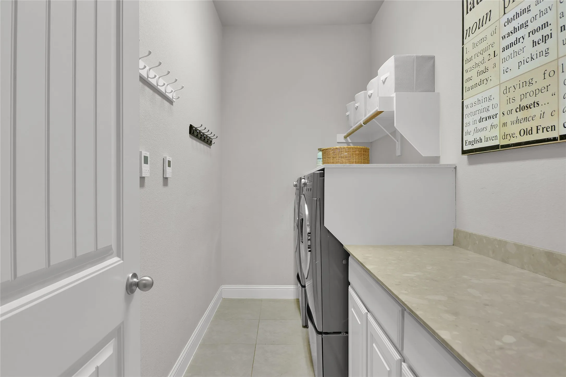 Laundry room with hanging rack, cabinets and folding space.