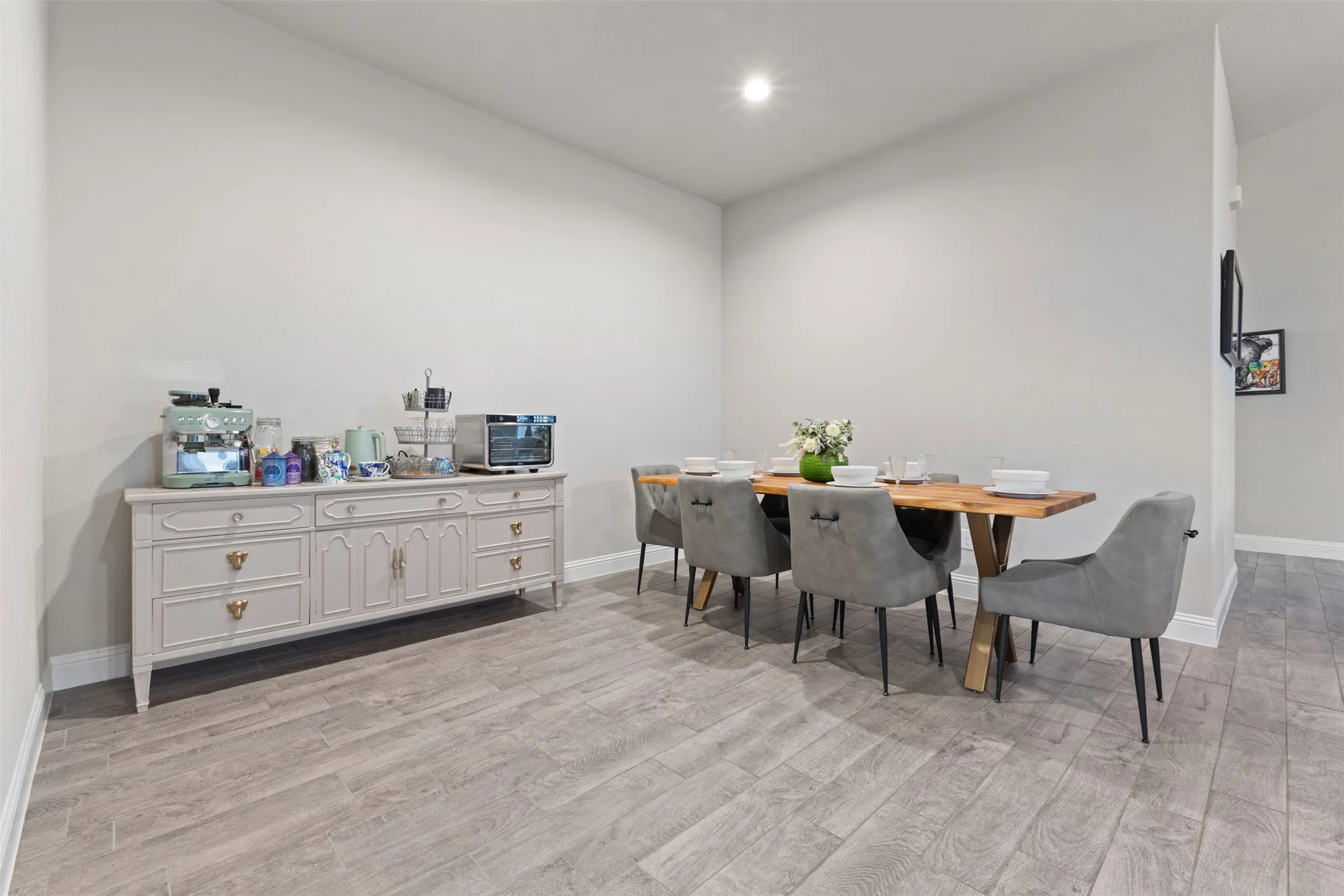 Spacious room featuring light gray walls and wood-finish flooring