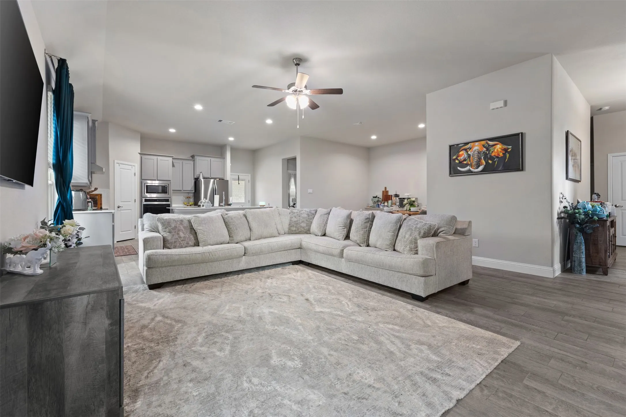 Open-concept living area featuring recessed lighting, a ceiling fan, and wood-finish flooring