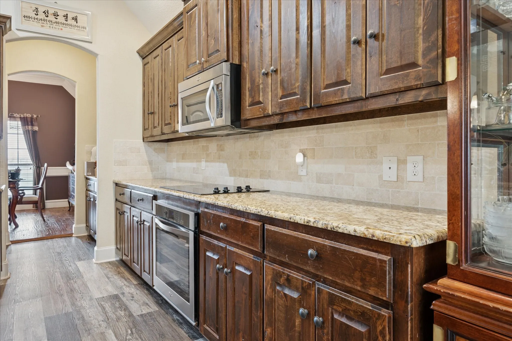 Rich wood cabinetry paired with light granite-look countertops