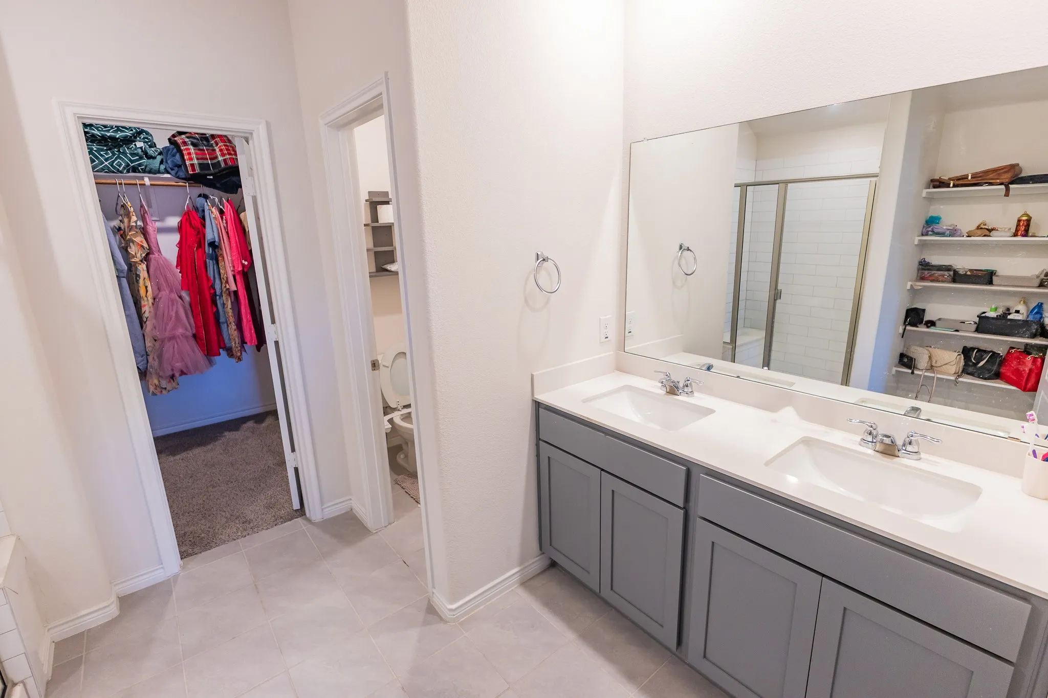 Bathroom featuring a double vanity with gray cabinetry, white countertops, and dual undermount sinks
