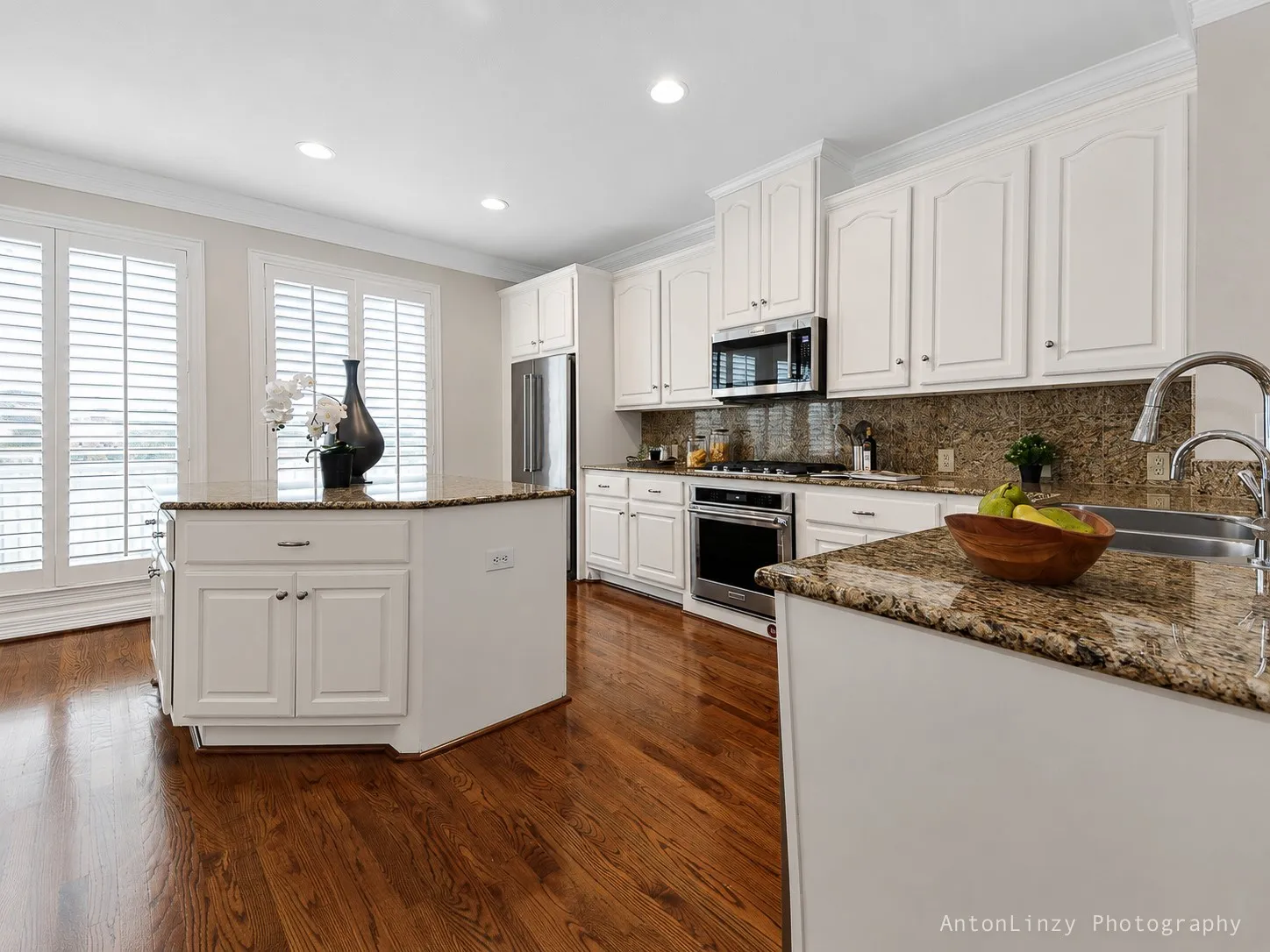 Kitchen features large island, granite countertops, and stainless steel appliances