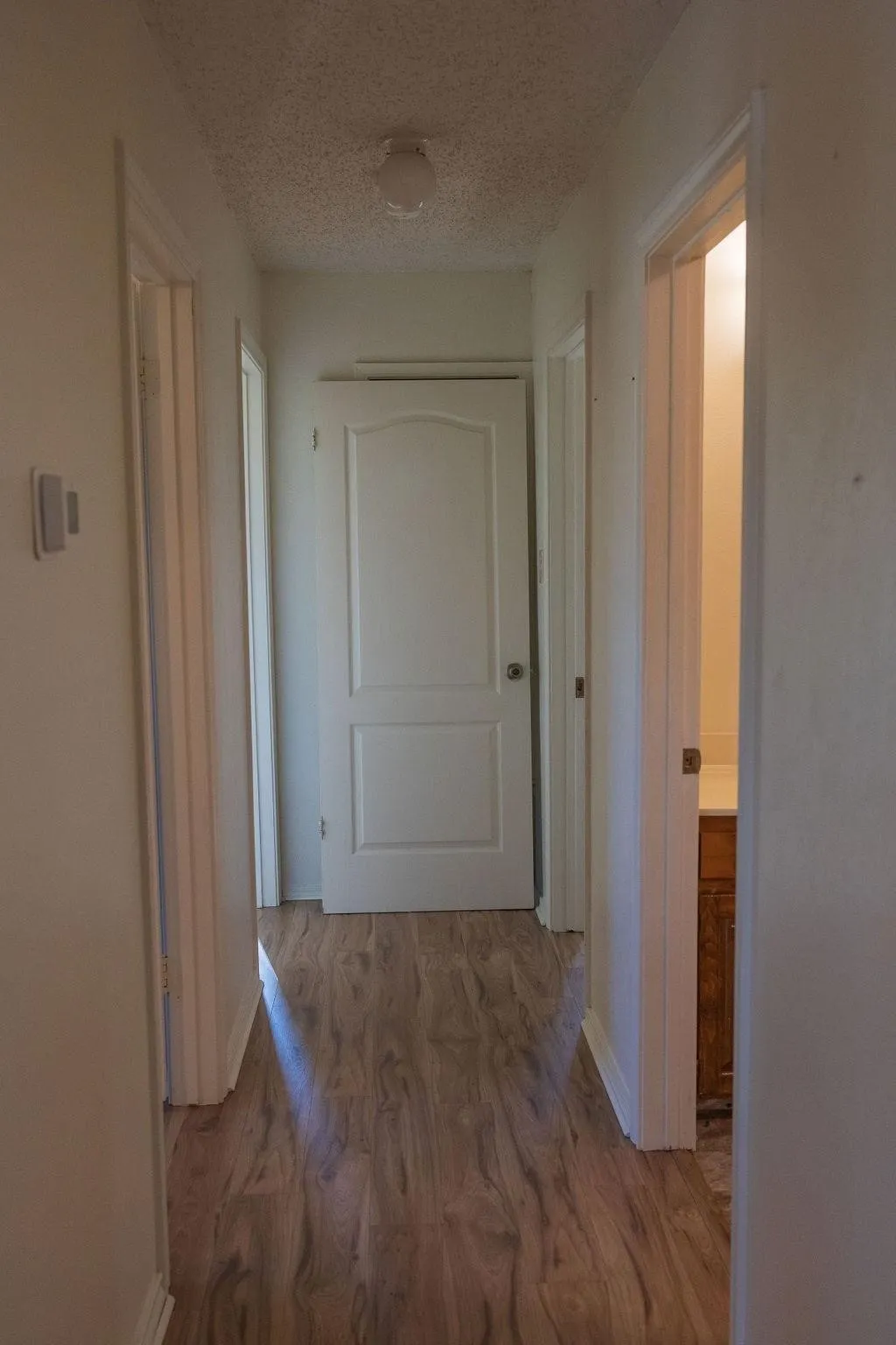 Hallway with wood-finish flooring and white baseboards