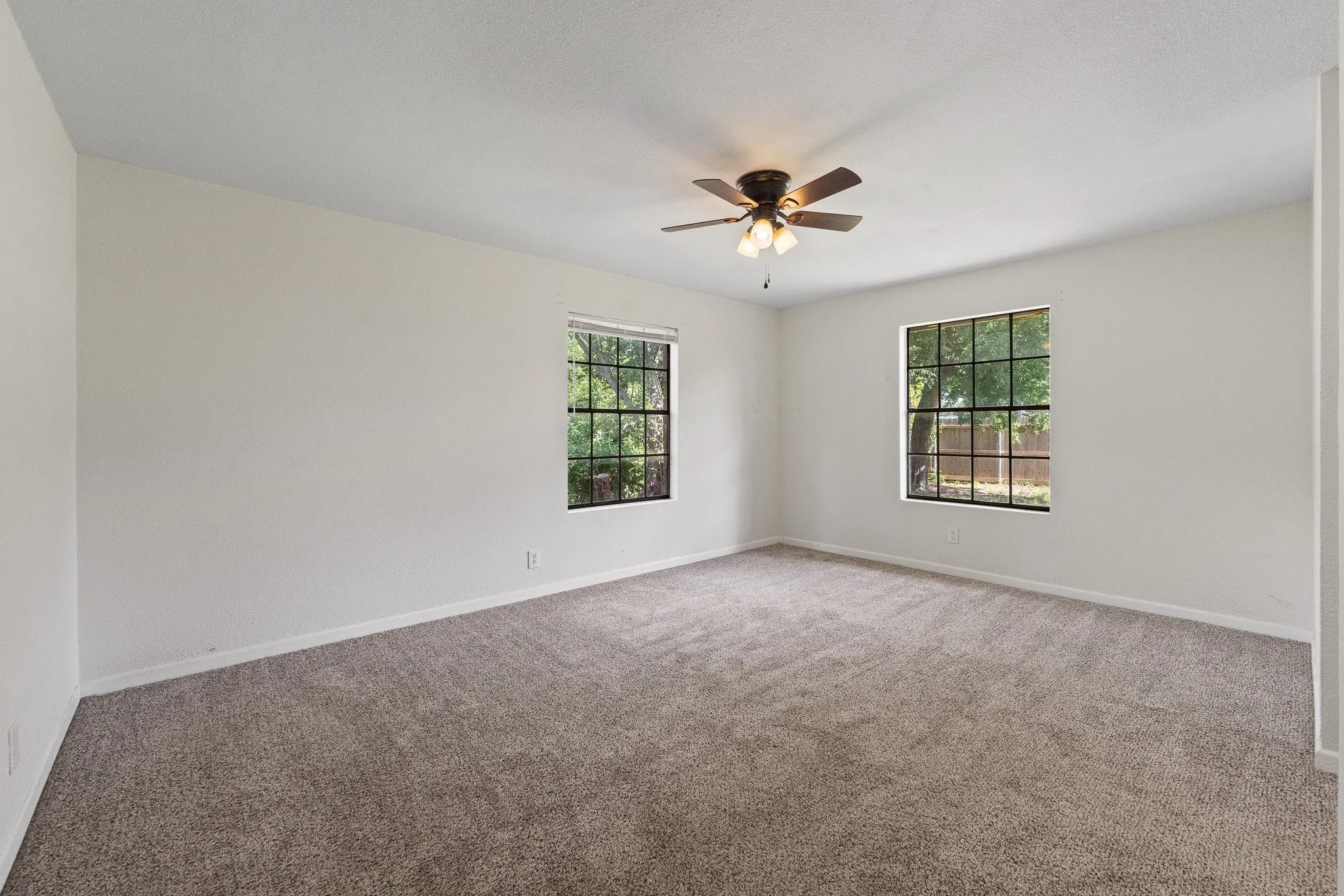 Spacious room featuring neutral carpeting and white wall finishes