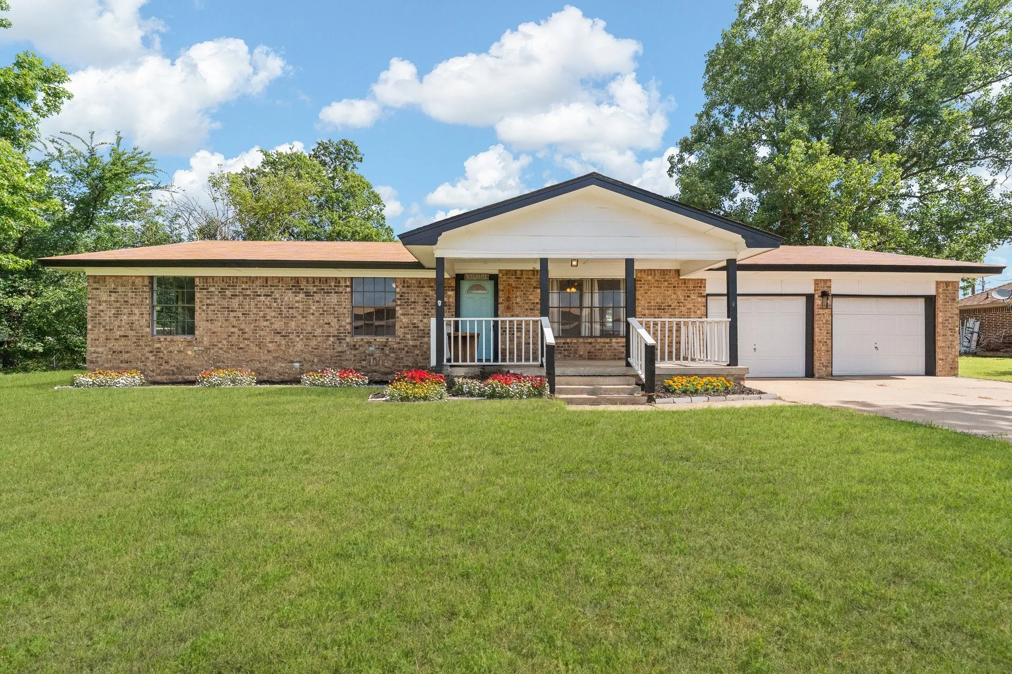 VIRTUALLY ENHANCED Brick exterior with contrasting dark trim and a two-car garage