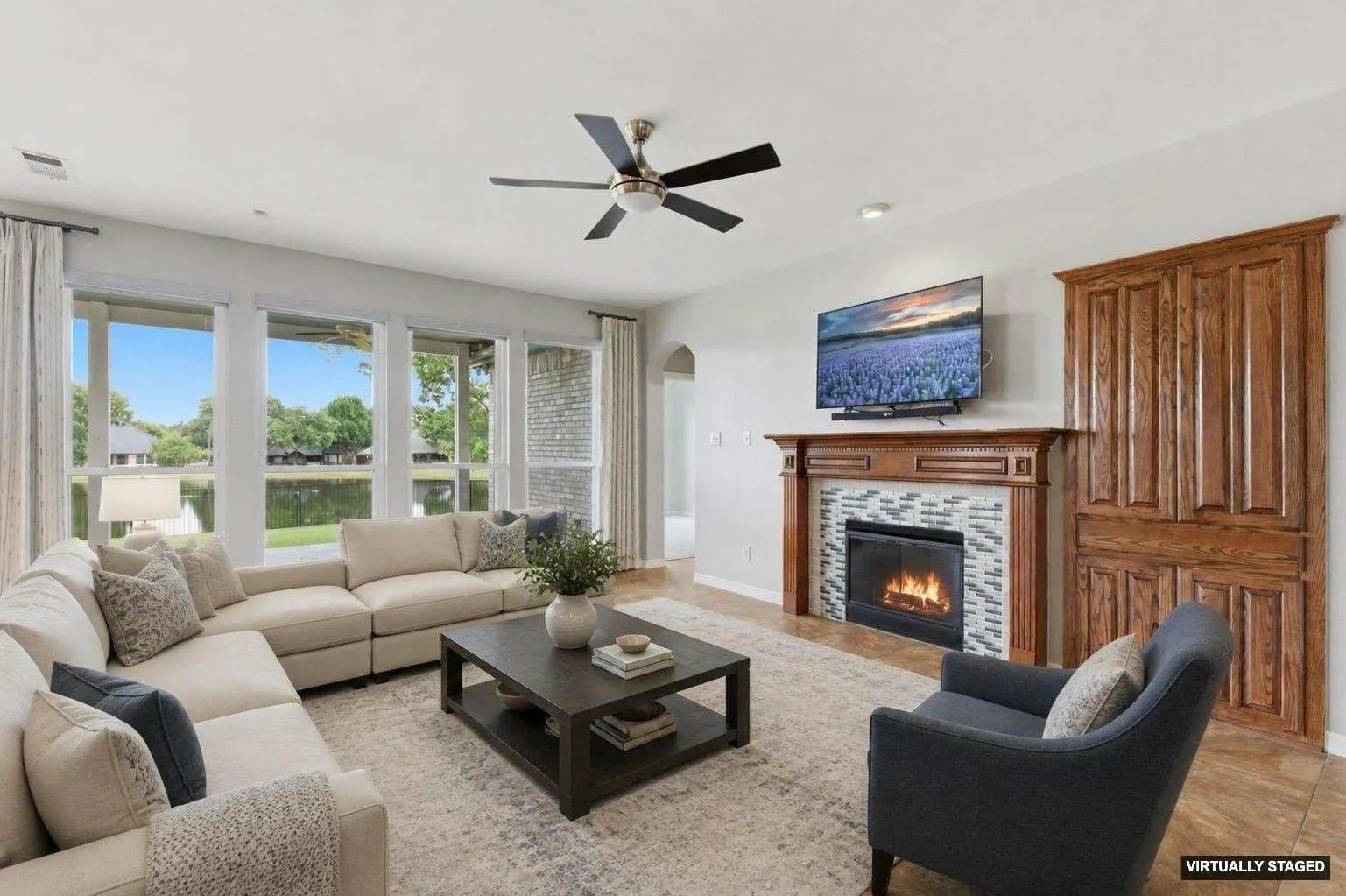 Built in cabinet for electronics, glowing gas log fireplace and room darkening roller shades to a relaxing evening indoors. FURNITURE is virtually staged to show perspective.