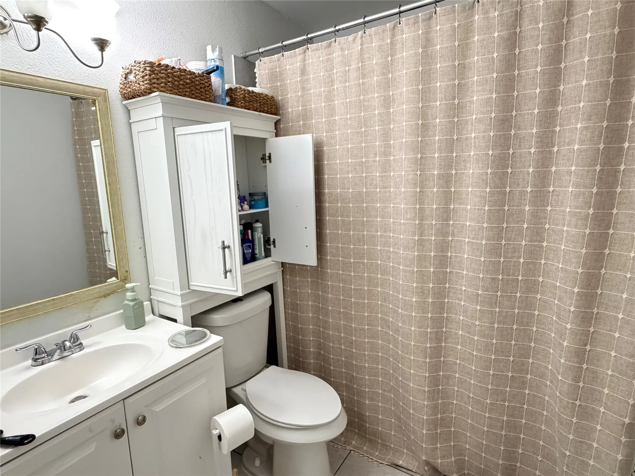 Bathroom featuring a white vanity with integrated sink, chrome faucet, and storage cabinetry