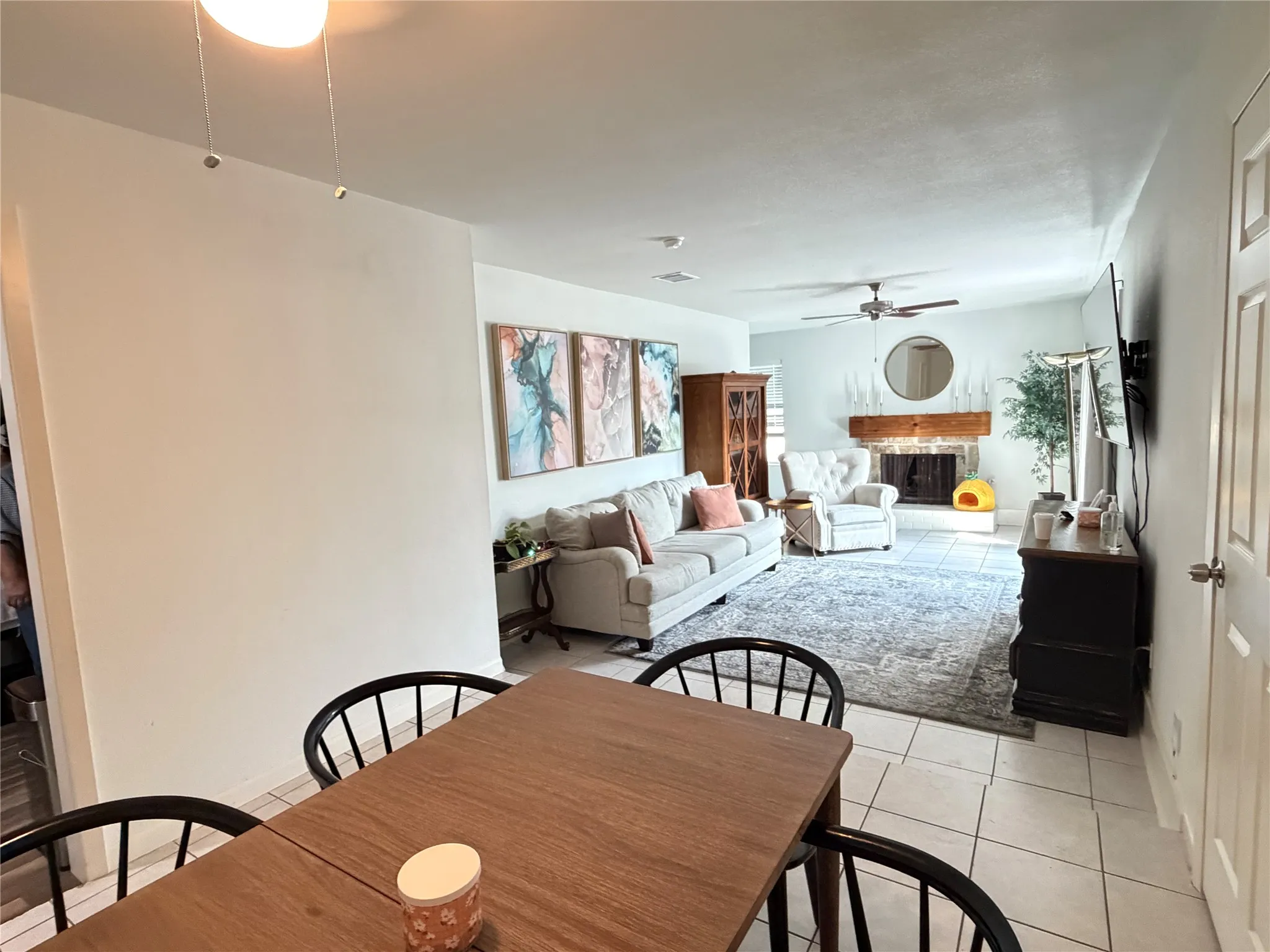 Open-concept living space featuring a wood-finish dining table and tile flooring