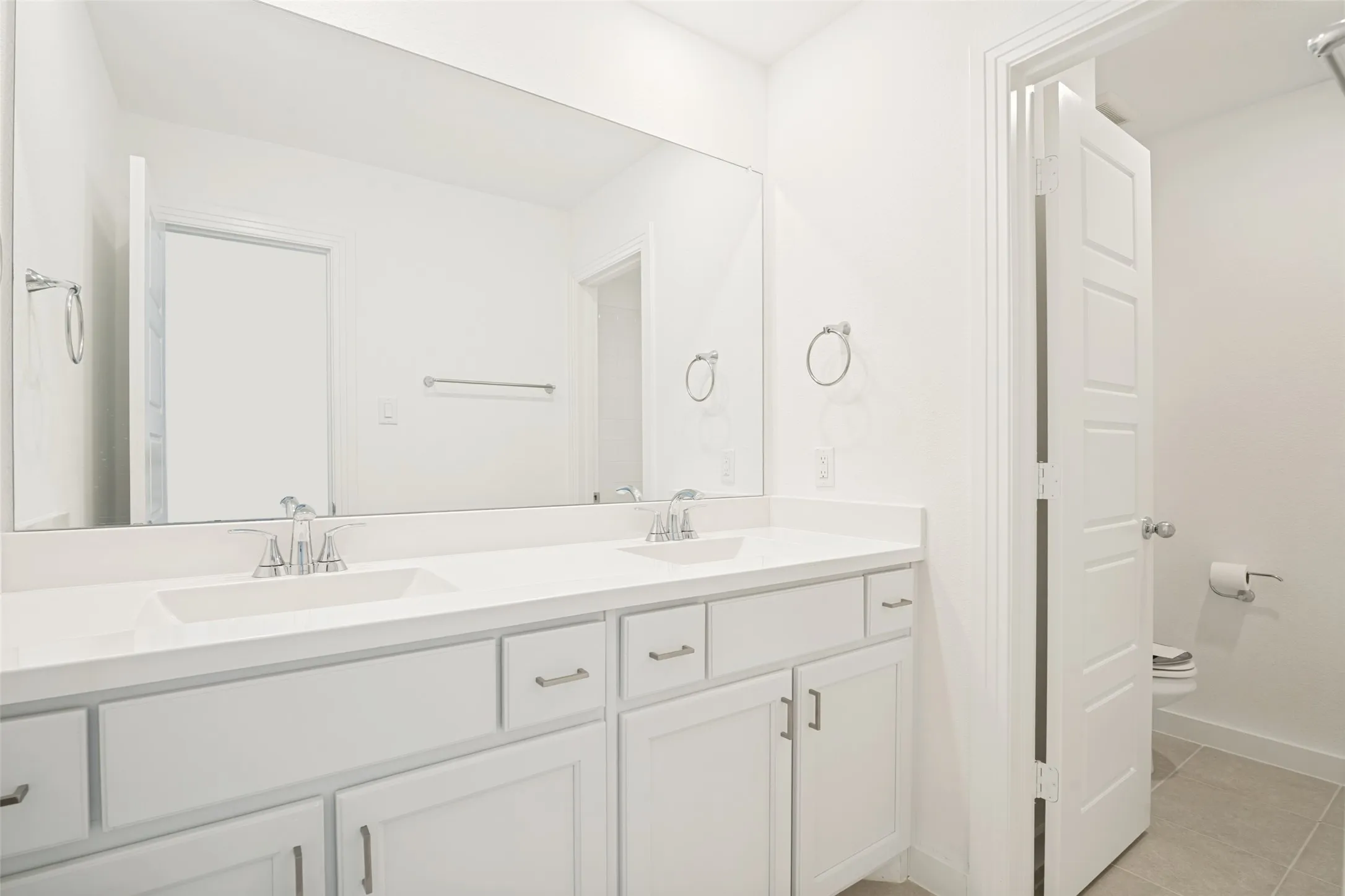 Dual vanity with white cabinetry and integrated sinks set in a light-toned countertop