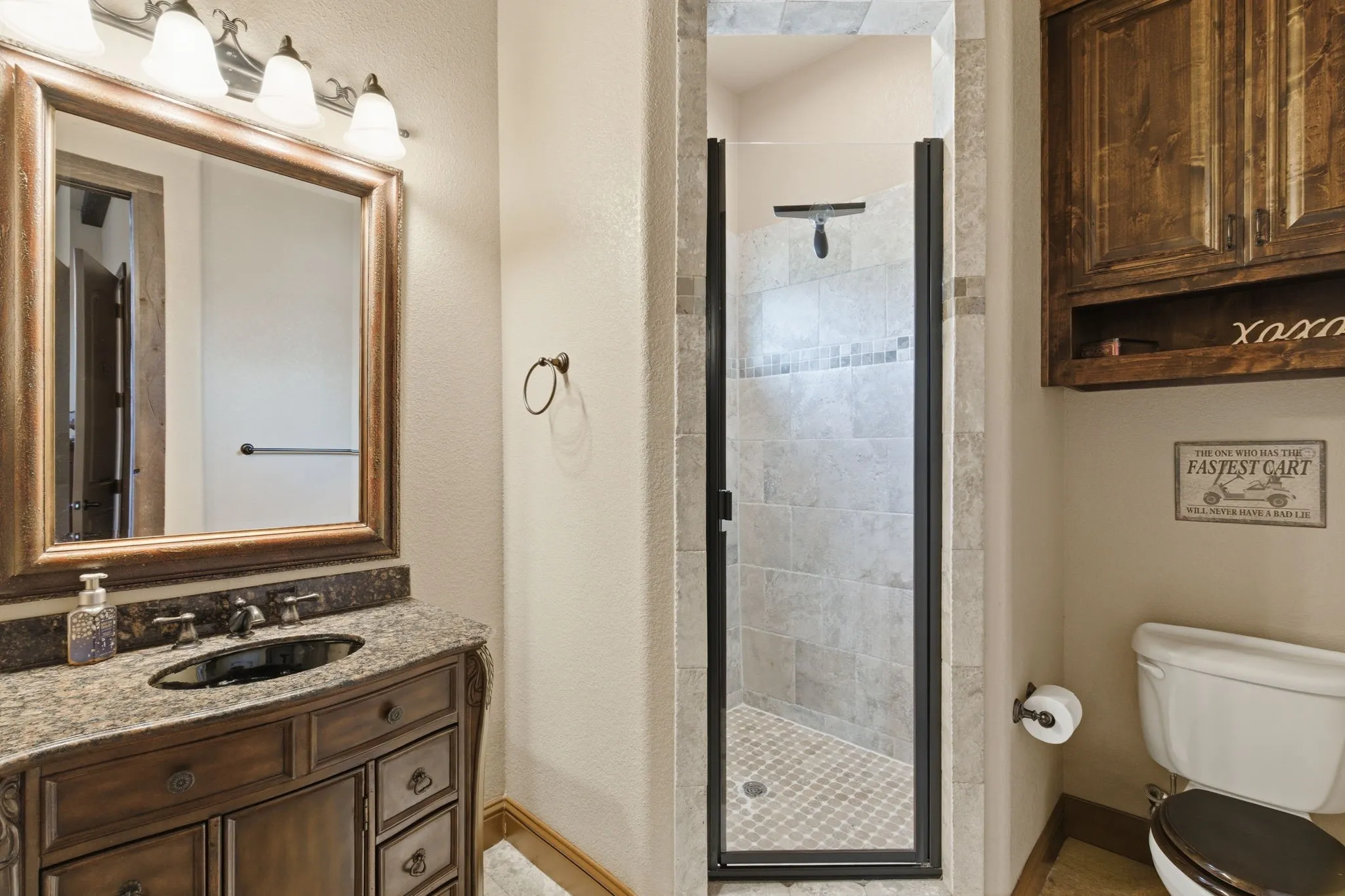 Bathroom featuring a vanity with a granite countertop and dark wood cabinetry