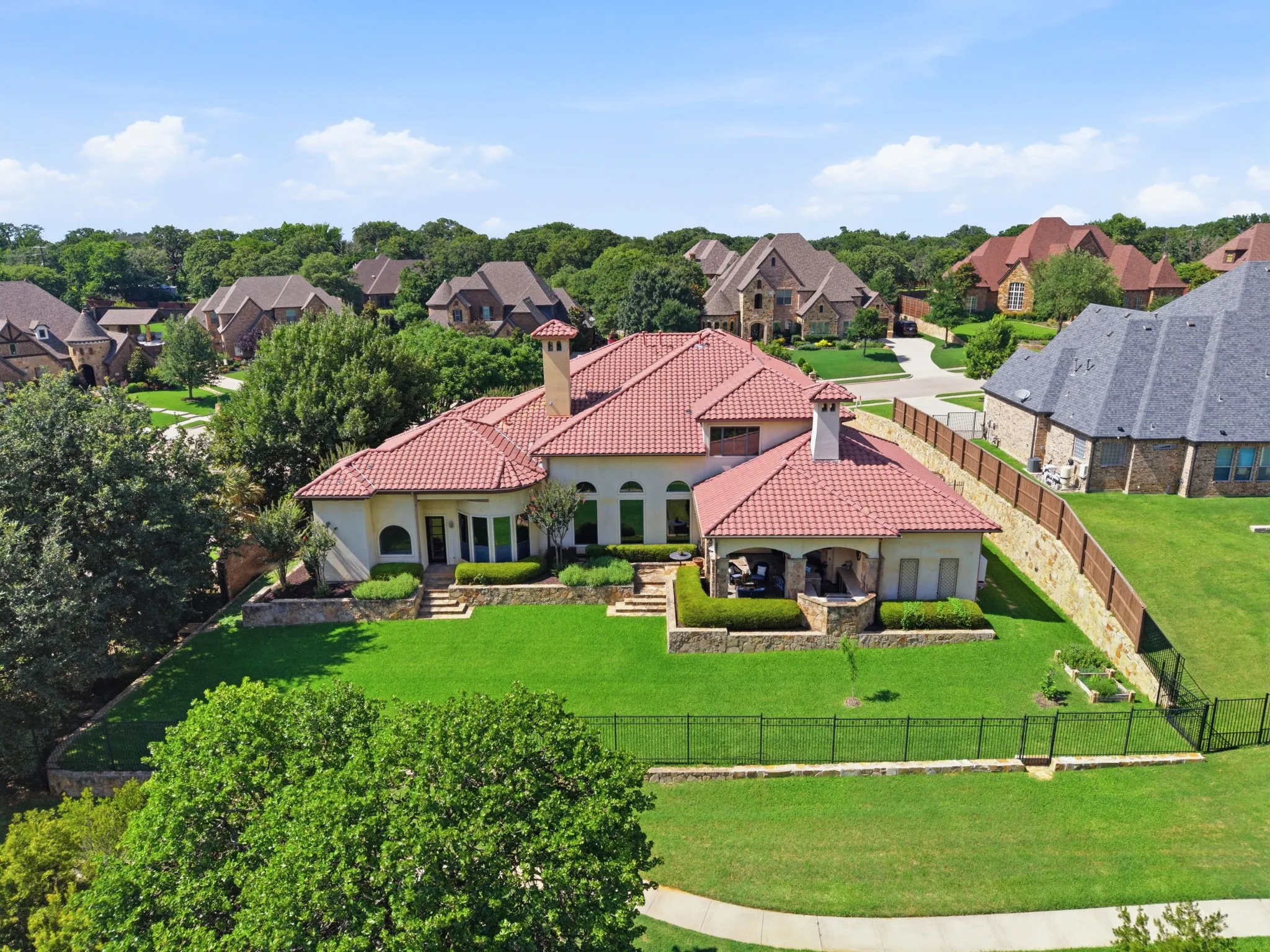 Mediterranean-style residence featuring a red tile roof and stucco exterior
