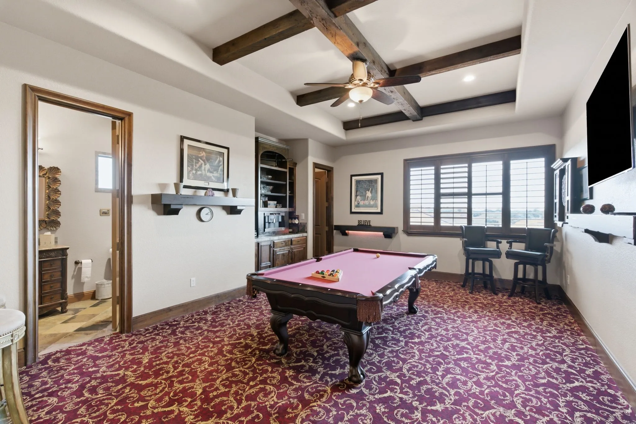 Entertainment room featuring exposed wood ceiling beams, and a built-in dry bar