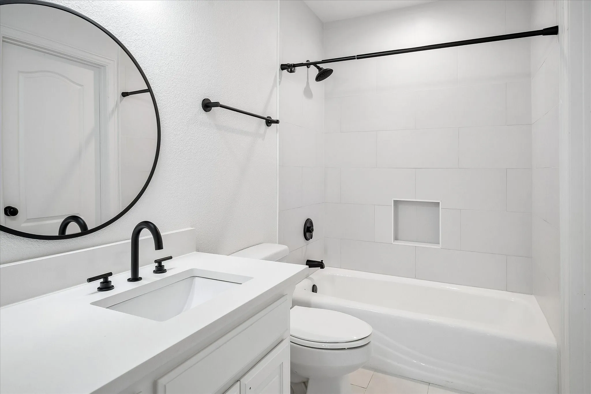 Bathroom featuring a white vanity with a rectangular undermount sink, a white countertop, and matte black fixtures