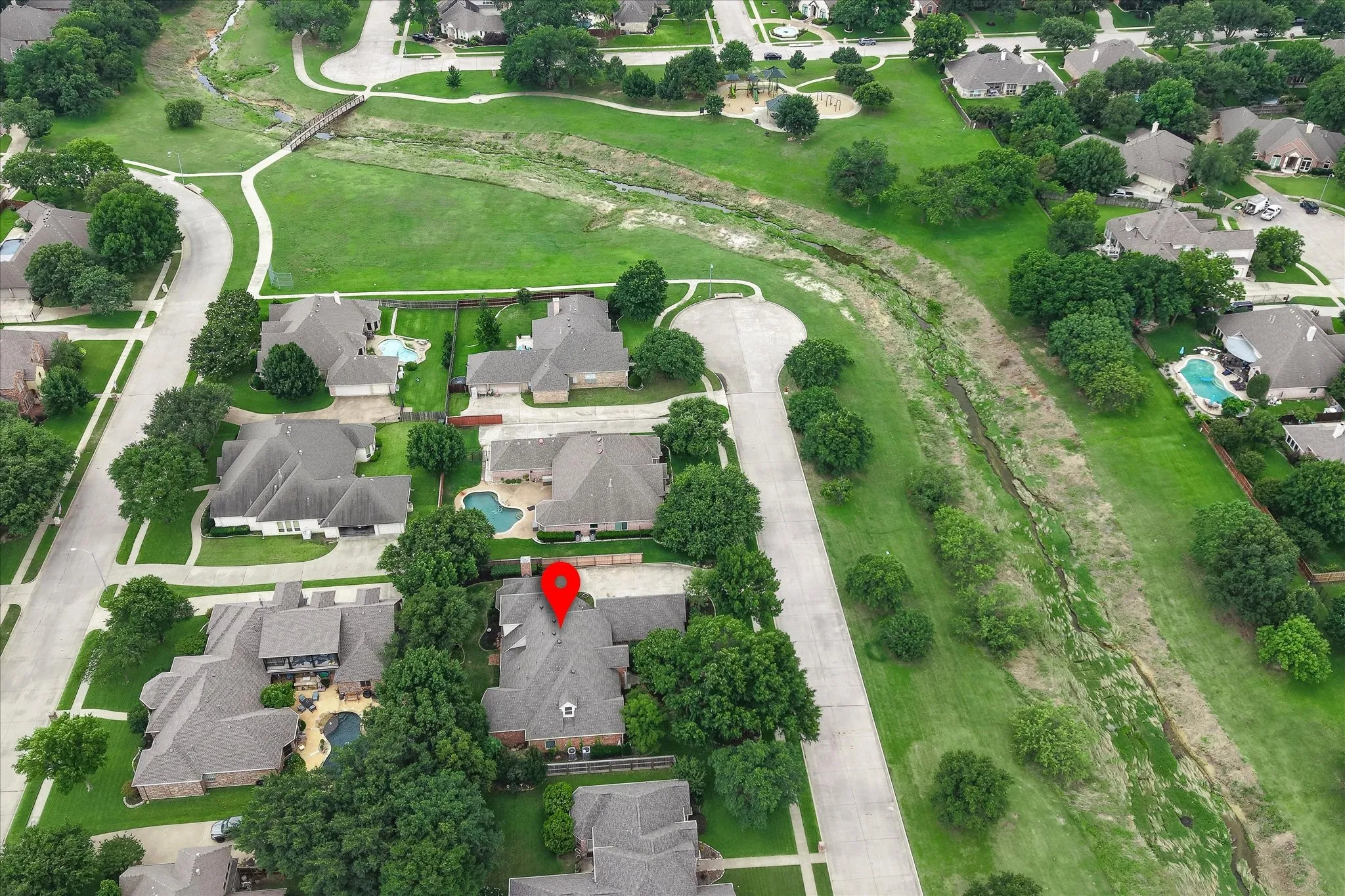Aerial view of a residential neighborhood with tree-lined streets and extensive green spaces