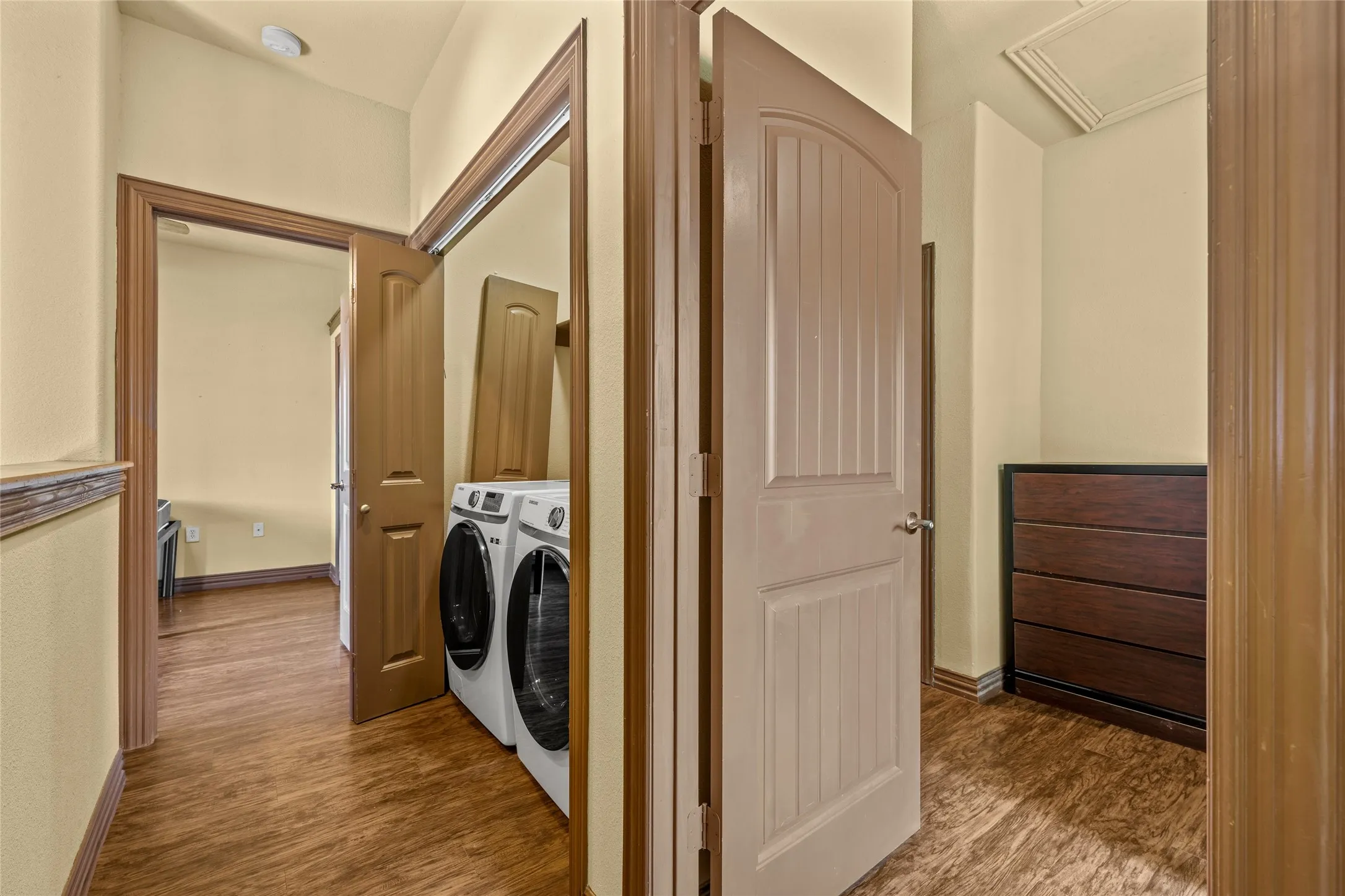 Laundry area featuring appliances, wood-finish flooring, and light-colored walls