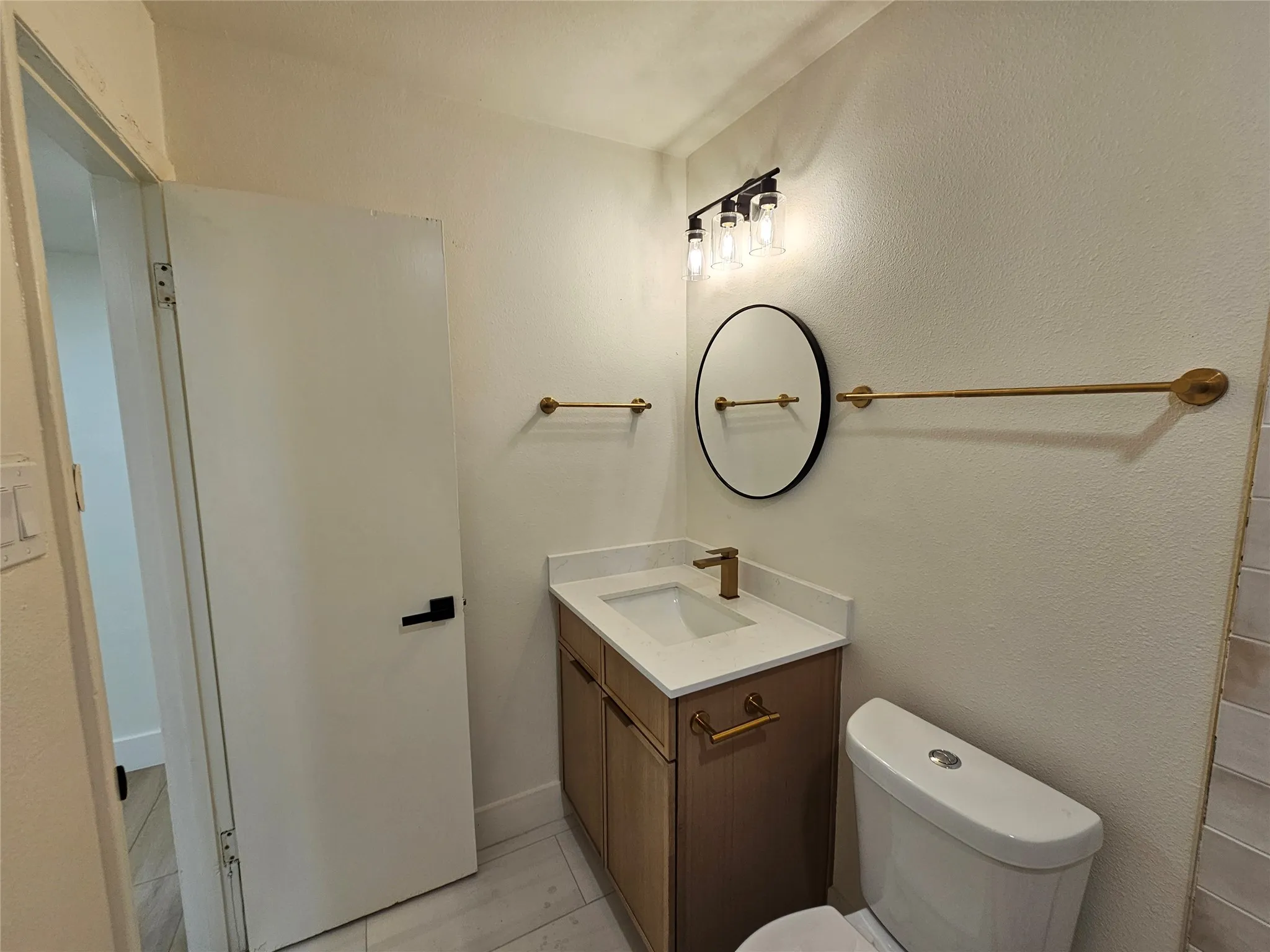 Bathroom featuring a vanity with a white countertop, undermount sink, and gold-tone faucet