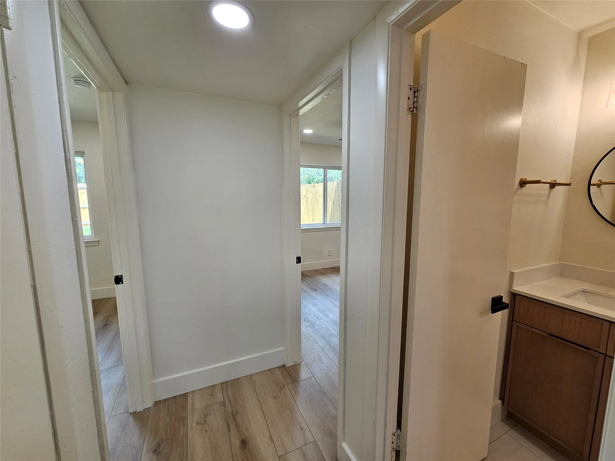 Hallway featuring wood-finish flooring, recessed lighting, and a neutral color palette